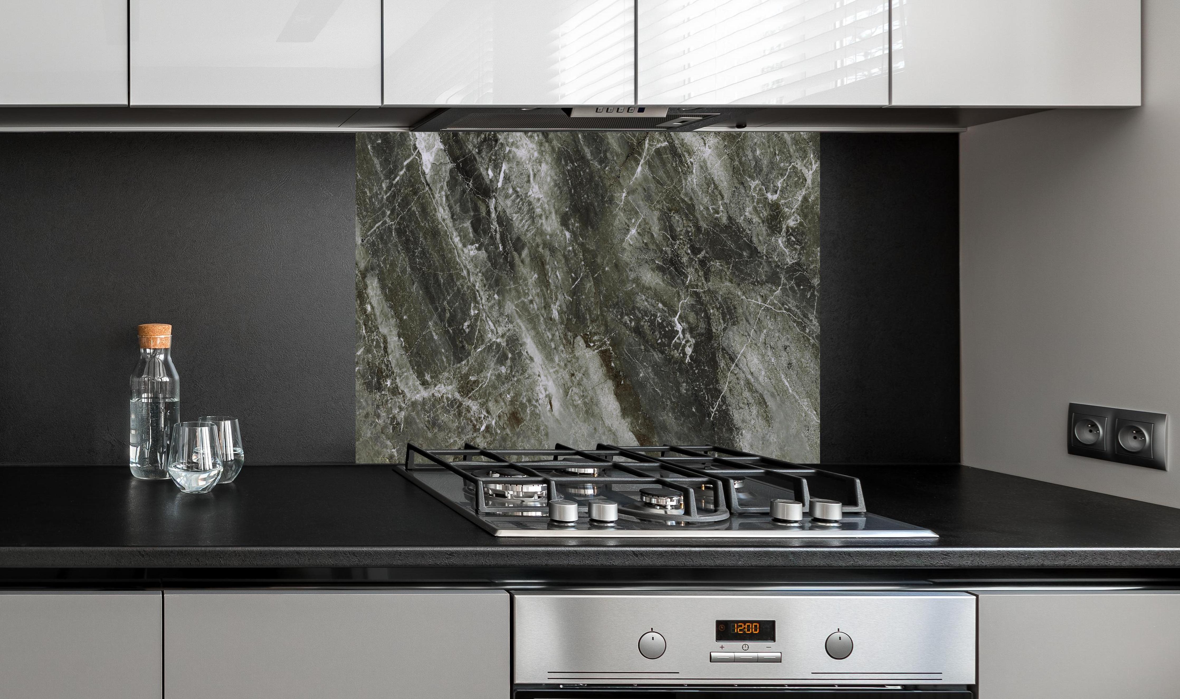 Spritzschutz - Moderne Marmor Textur  hinter einem Cerankochfeld zwischen Holz-Kochutensilien
