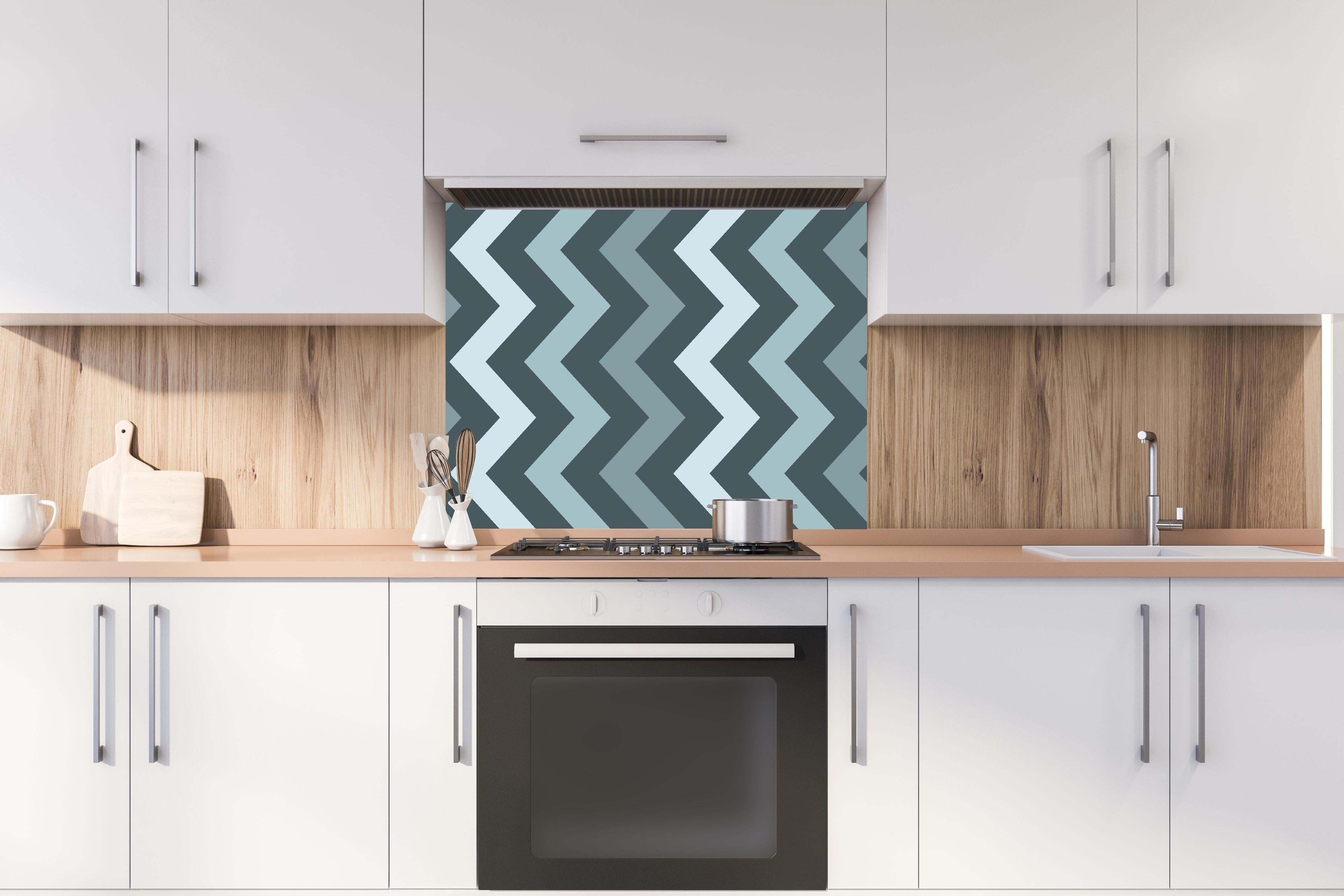 Spritzschutz - Modernes Chevron Design in Grau-Weiß hinter einem Cerankochfeld zwischen Holz-Kochutensilien

