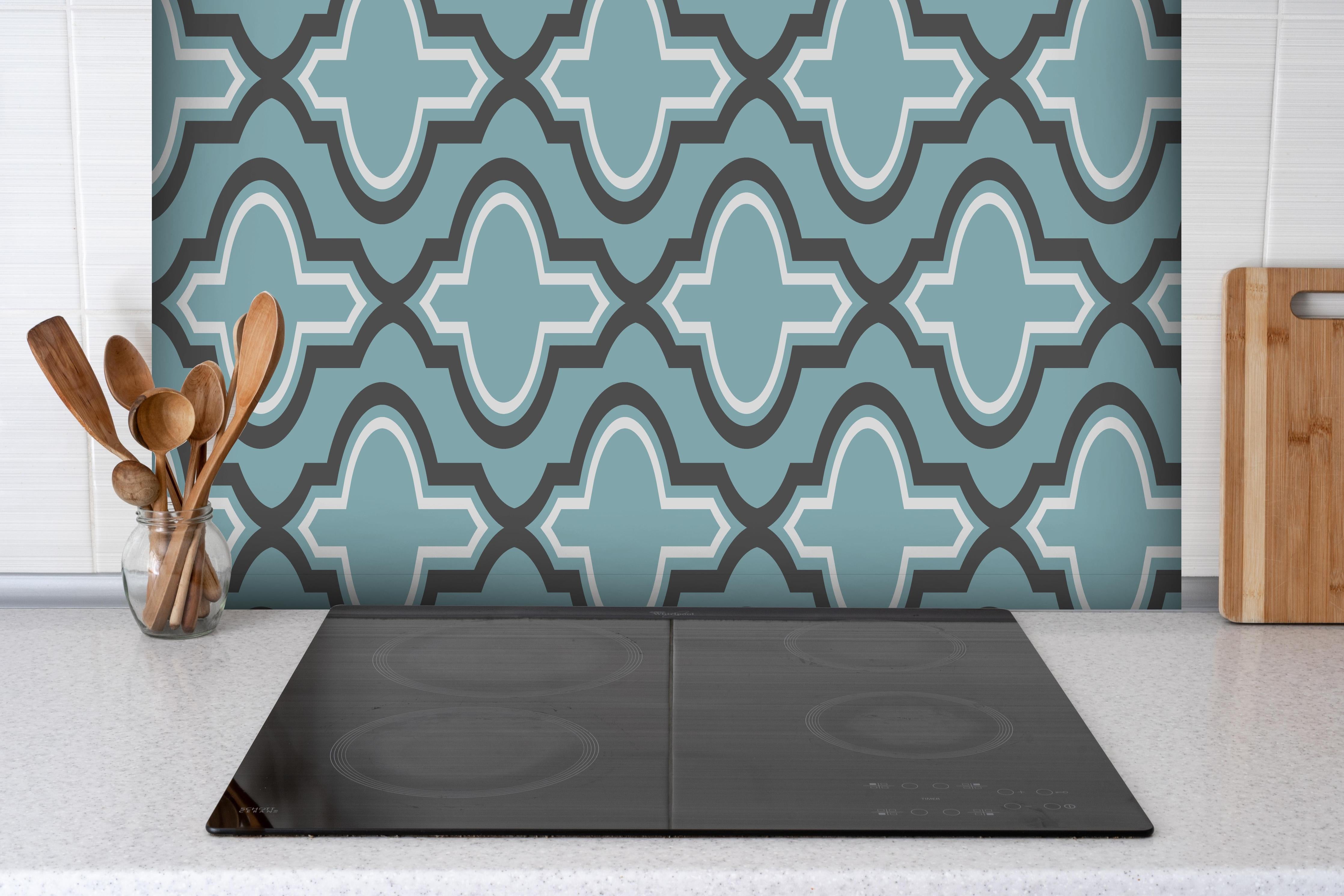 Spritzschutz - Modernes Grau und Weißes Grafikmuster hinter einem Cerankochfeld zwischen Holz-Kochutensilien
