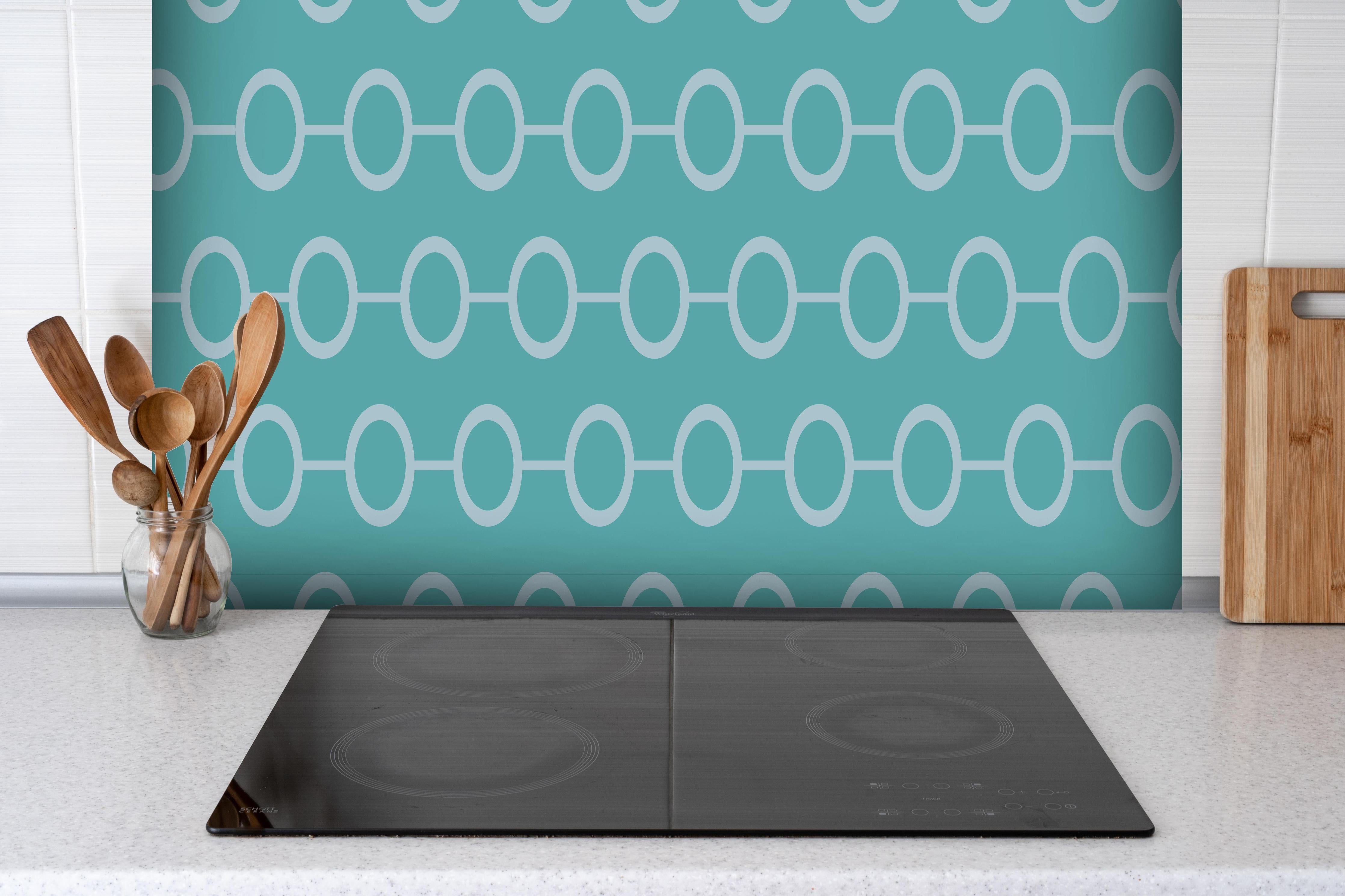 Spritzschutz - Modernes Türkis und Weiß Kettendesign hinter einem Cerankochfeld zwischen Holz-Kochutensilien
