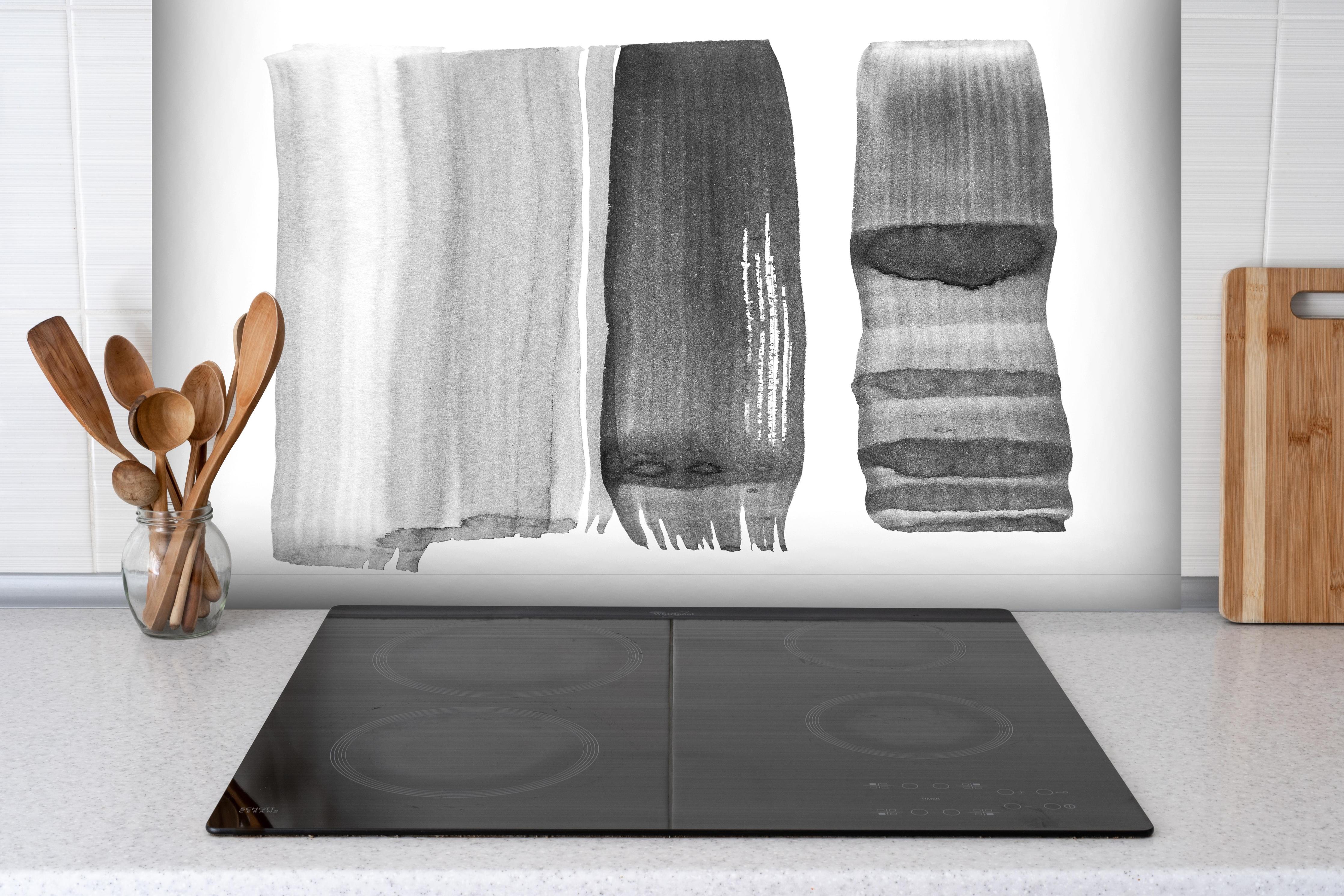 Spritzschutz - Monochrome Abstraktion in Schwarz und Weiß hinter einem Cerankochfeld zwischen Holz-Kochutensilien
