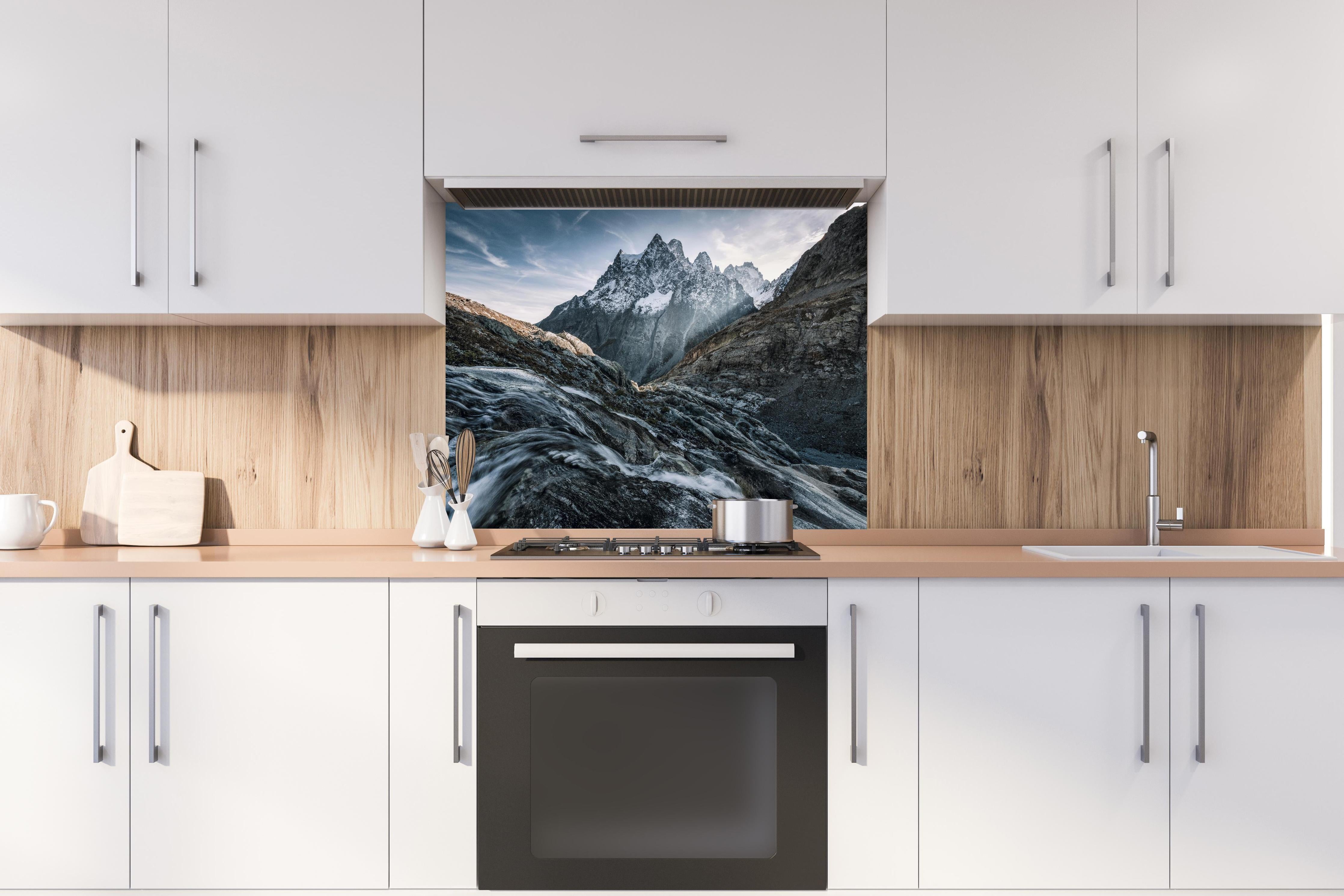 Spritzschutz - Monochrome Berggipfel mit Fluss hinter einem Cerankochfeld zwischen Holz-Kochutensilien

