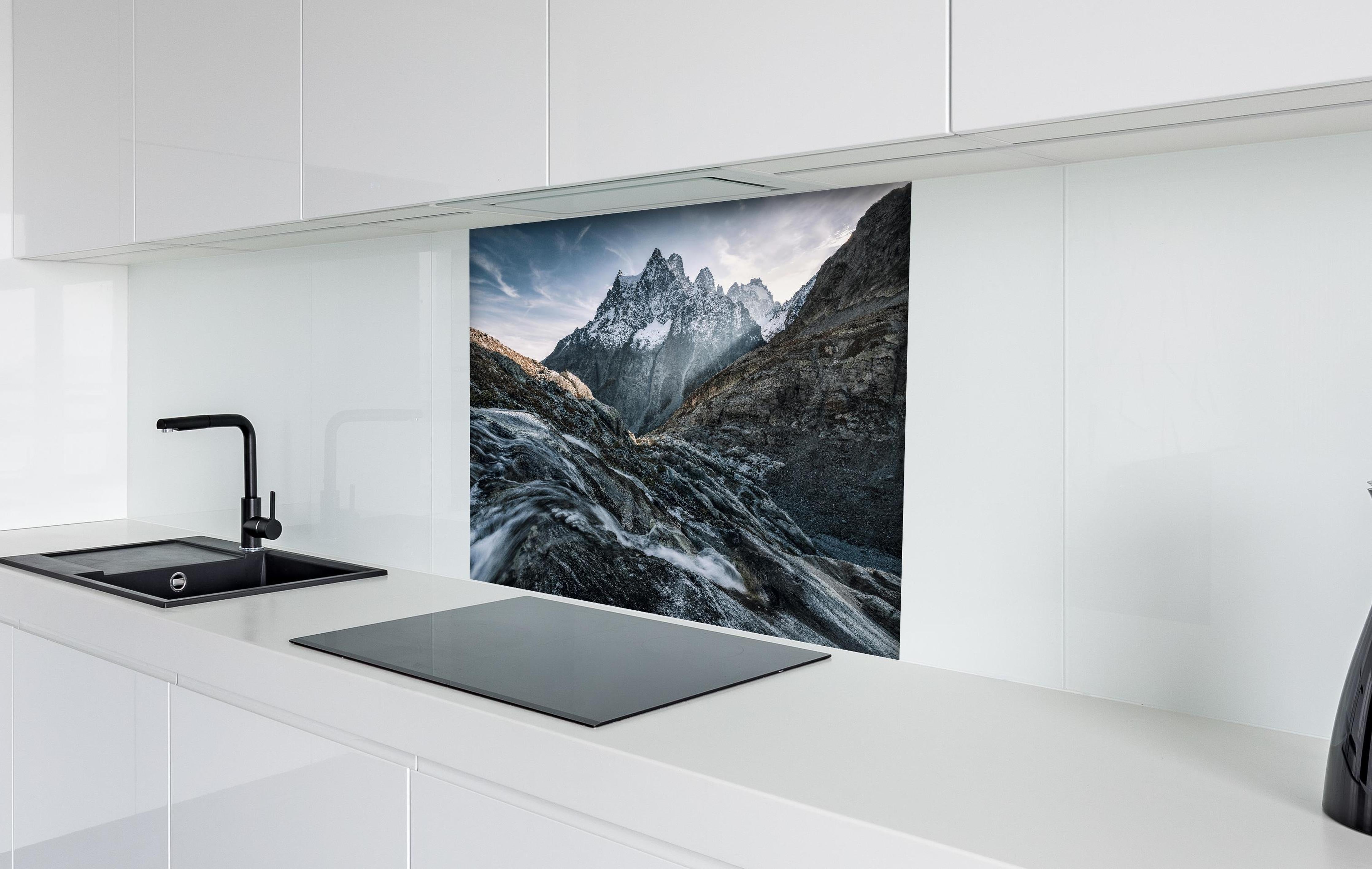 Spritzschutz - Monochrome Berggipfel mit Fluss hinter einem Cerankochfeld zwischen Holz-Kochutensilien
