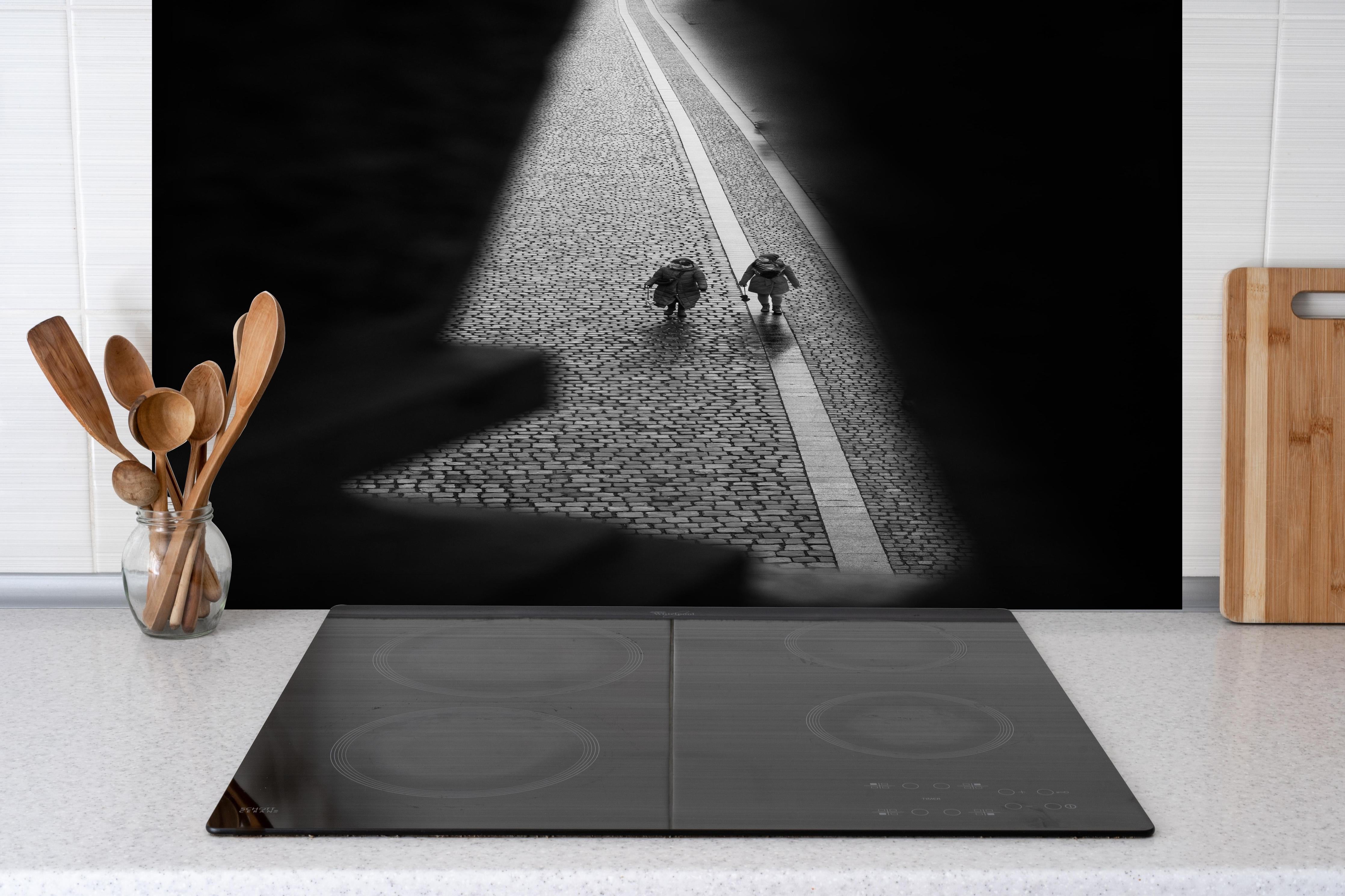 Spritzschutz - Monochrome Prager Straßenansicht mit Personen hinter einem Cerankochfeld zwischen Holz-Kochutensilien
