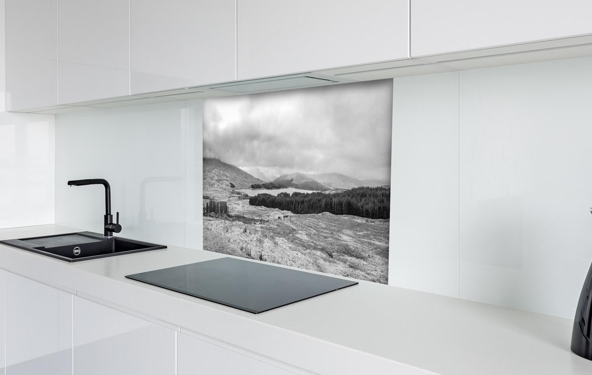 Spritzschutz - Monochrome Winterlandschaft Highlands hinter einem Cerankochfeld zwischen Holz-Kochutensilien
