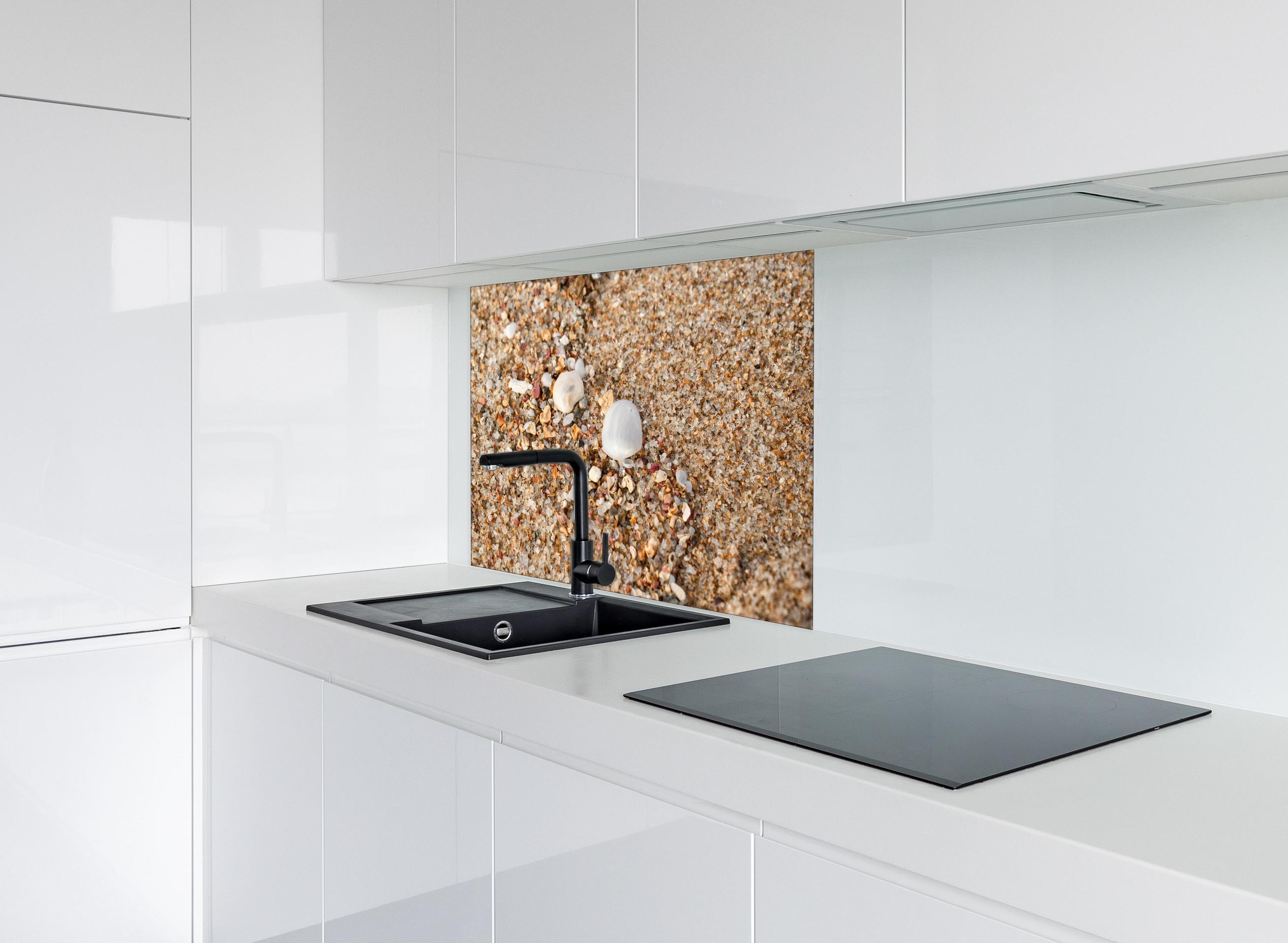 Spritzschutz - Muscheln im Strandsand. Shell hinter einem Cerankochfeld zwischen Holz-Kochutensilien
