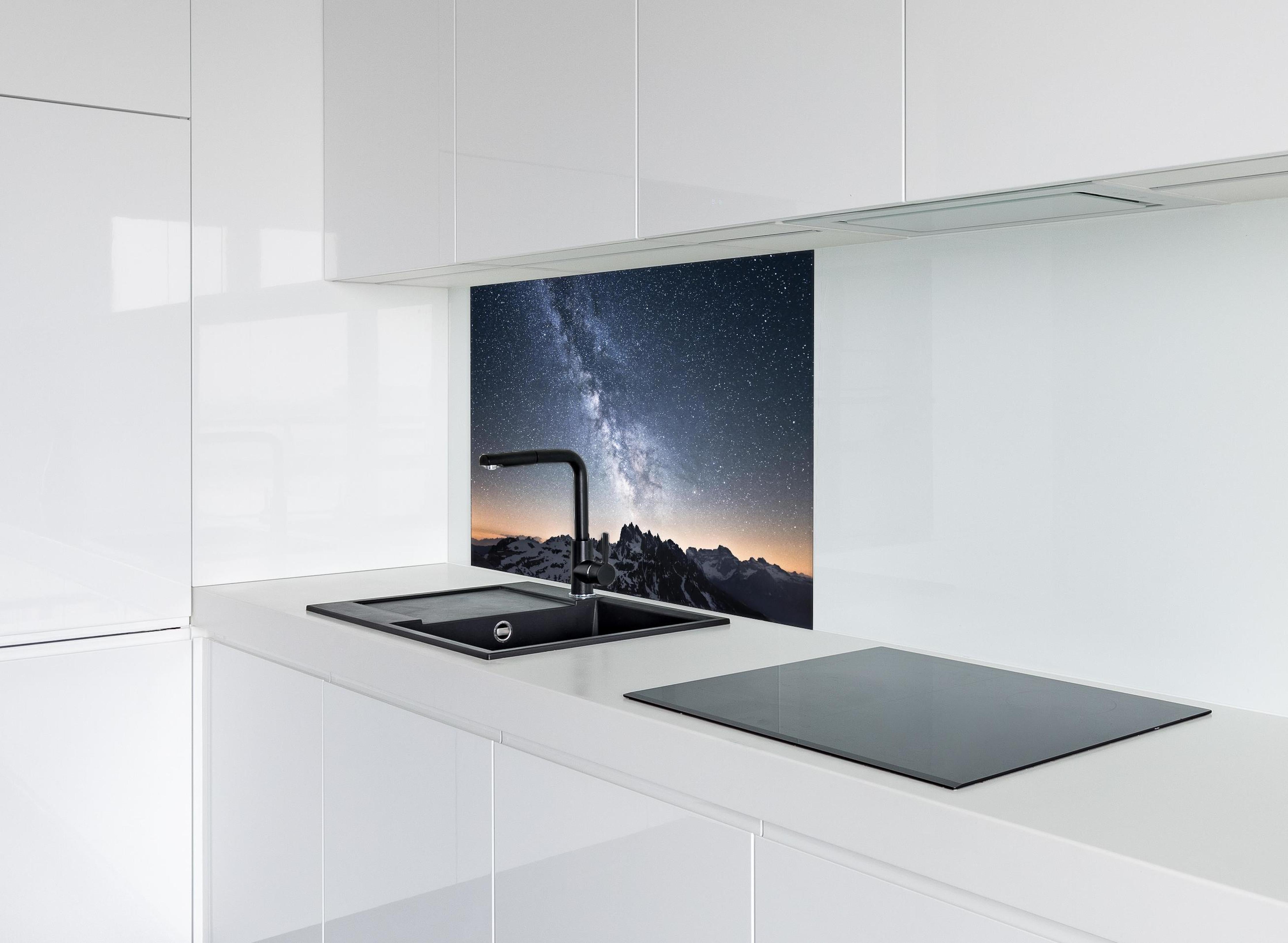 Spritzschutz - Nachthimmel Sterne Schneeberge Panorama hinter einem Cerankochfeld zwischen Holz-Kochutensilien
