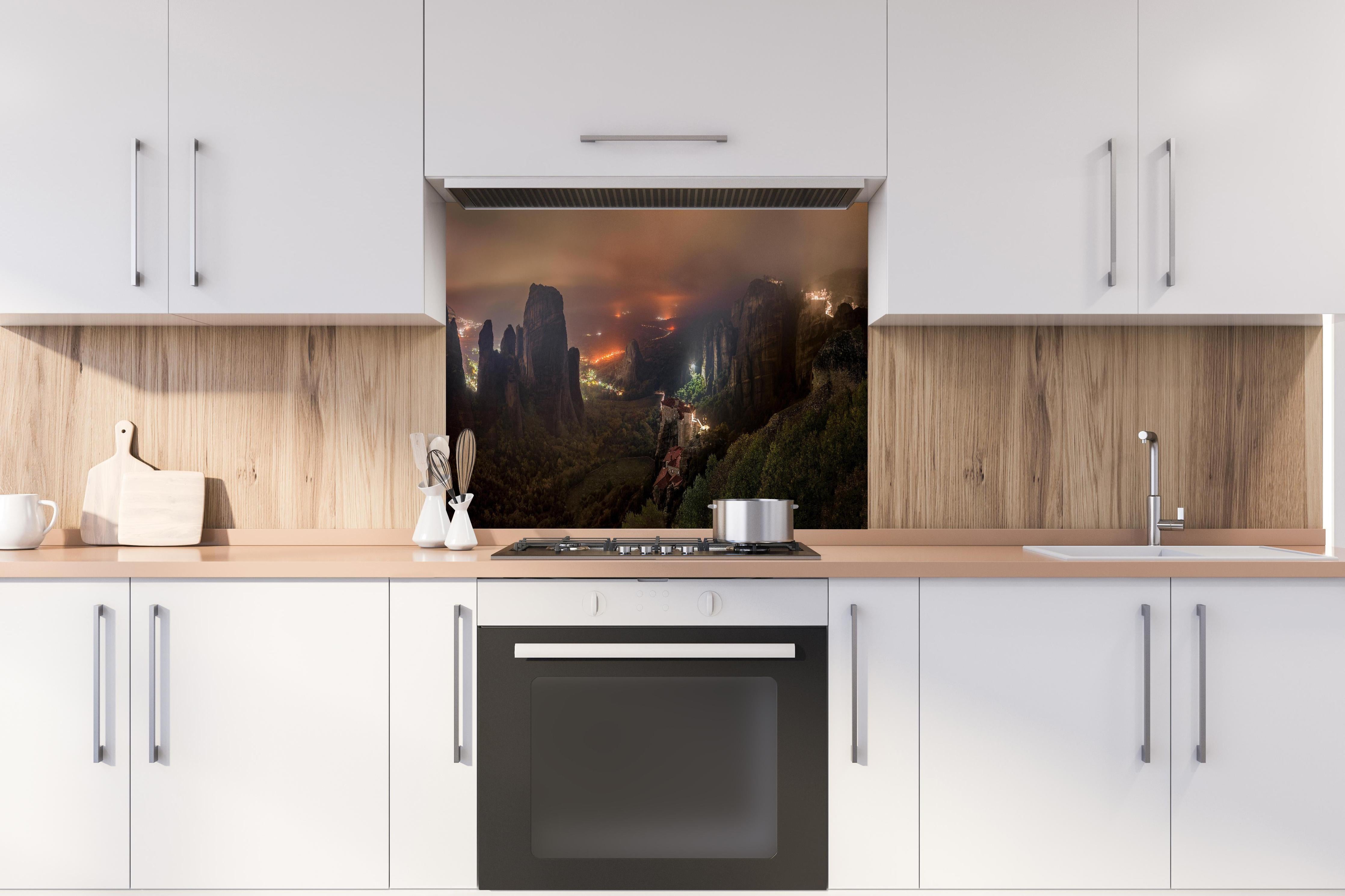 Spritzschutz - Nächtlicher Blick auf Meteora Berge hinter einem Cerankochfeld zwischen Holz-Kochutensilien
