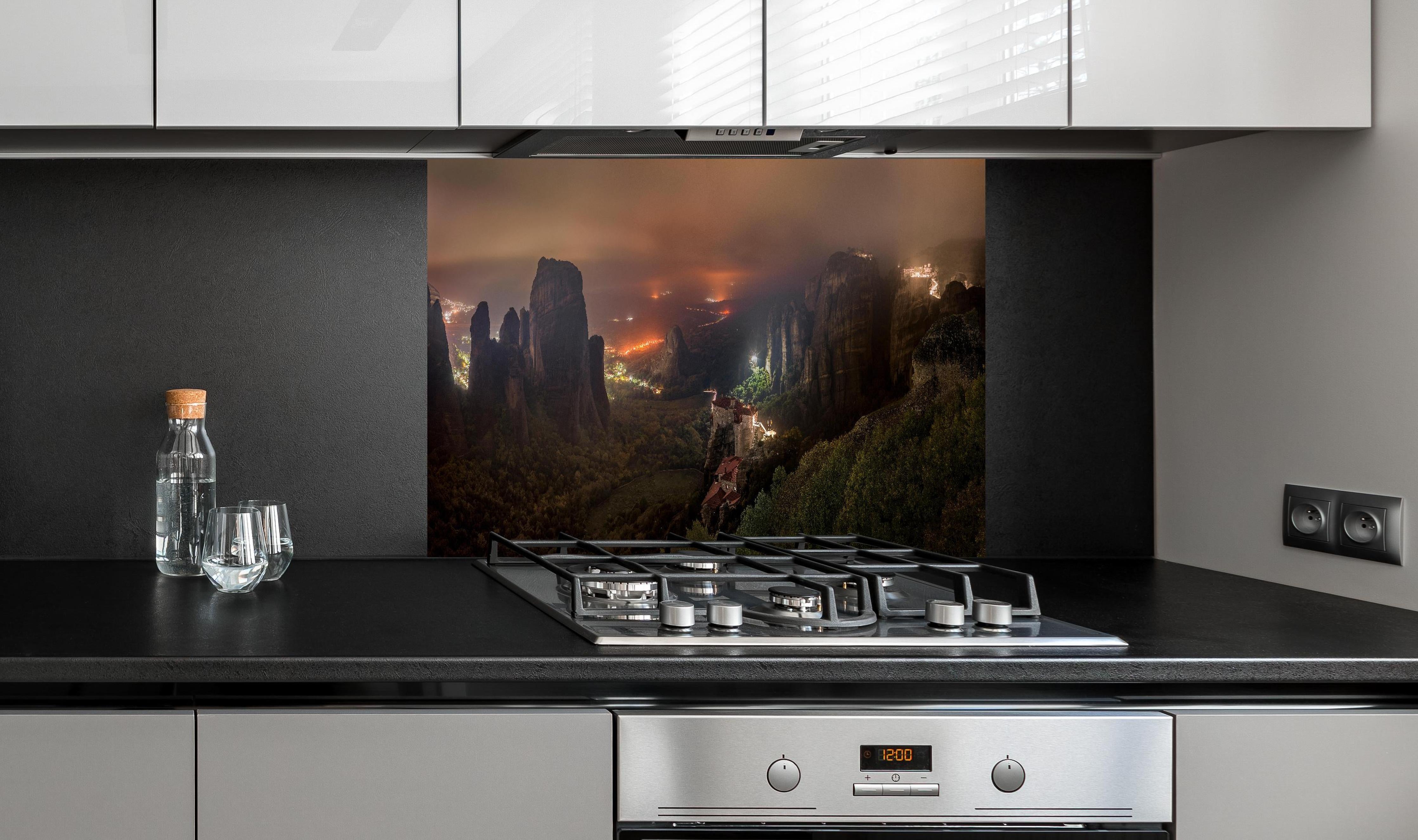 Spritzschutz - Nächtlicher Blick auf Meteora Berge hinter einem Cerankochfeld zwischen Holz-Kochutensilien
