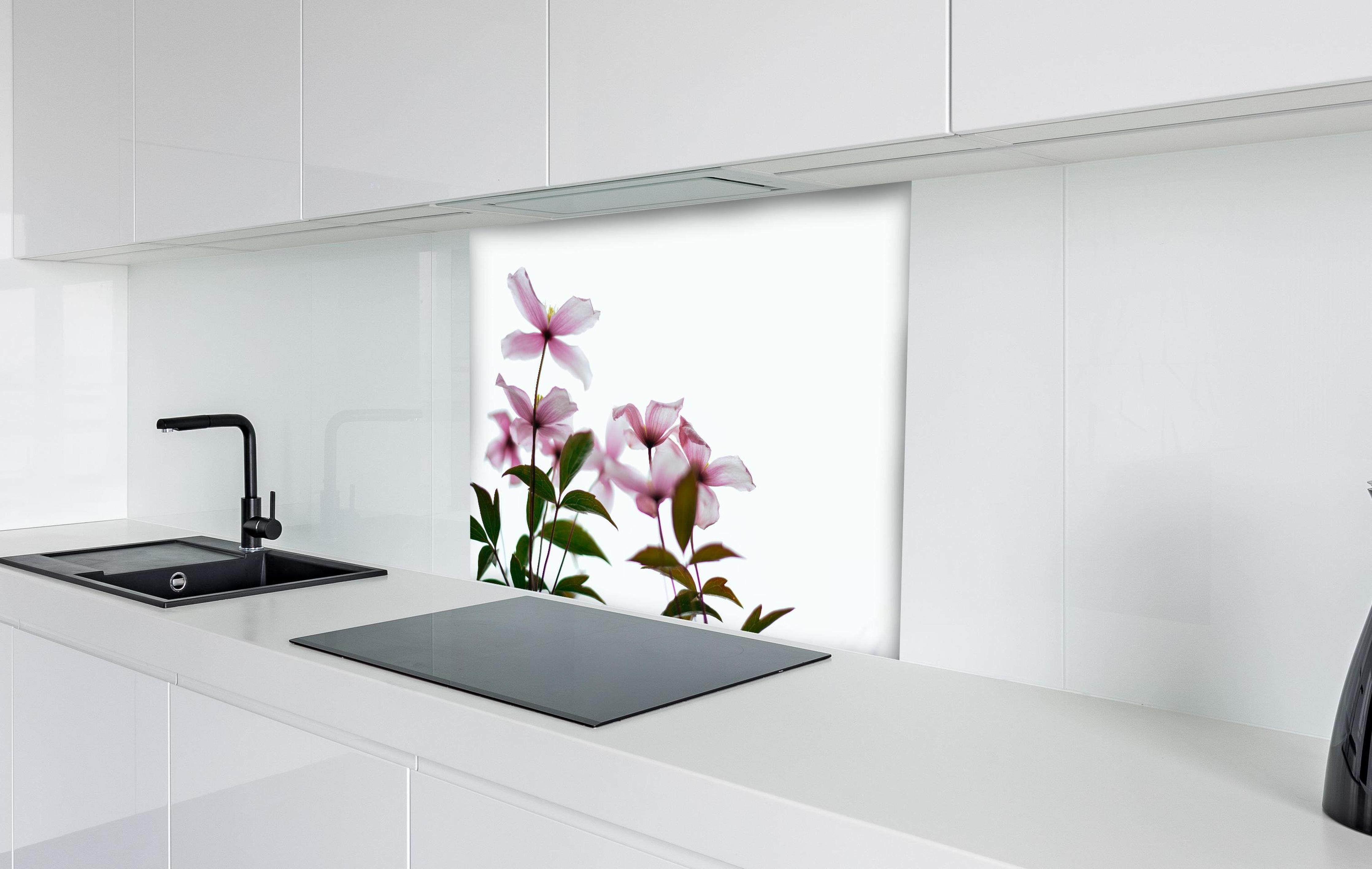 Spritzschutz - Nahaufnahme - Clematis Blüten hinter einem Cerankochfeld zwischen Holz-Kochutensilien
