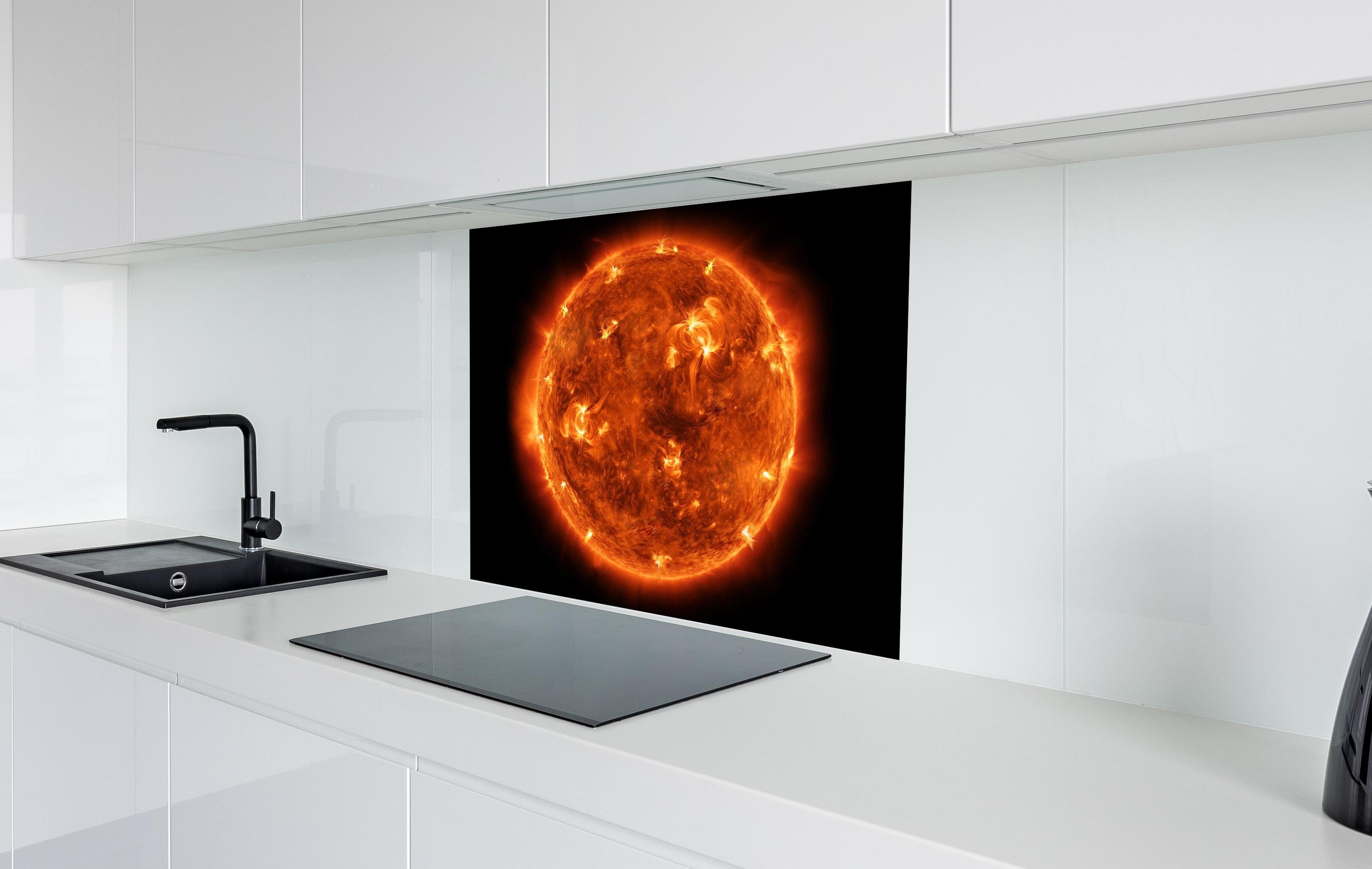 Spritzschutz - Nahaufnahme der Sonne hinter einem Cerankochfeld zwischen Holz-Kochutensilien
