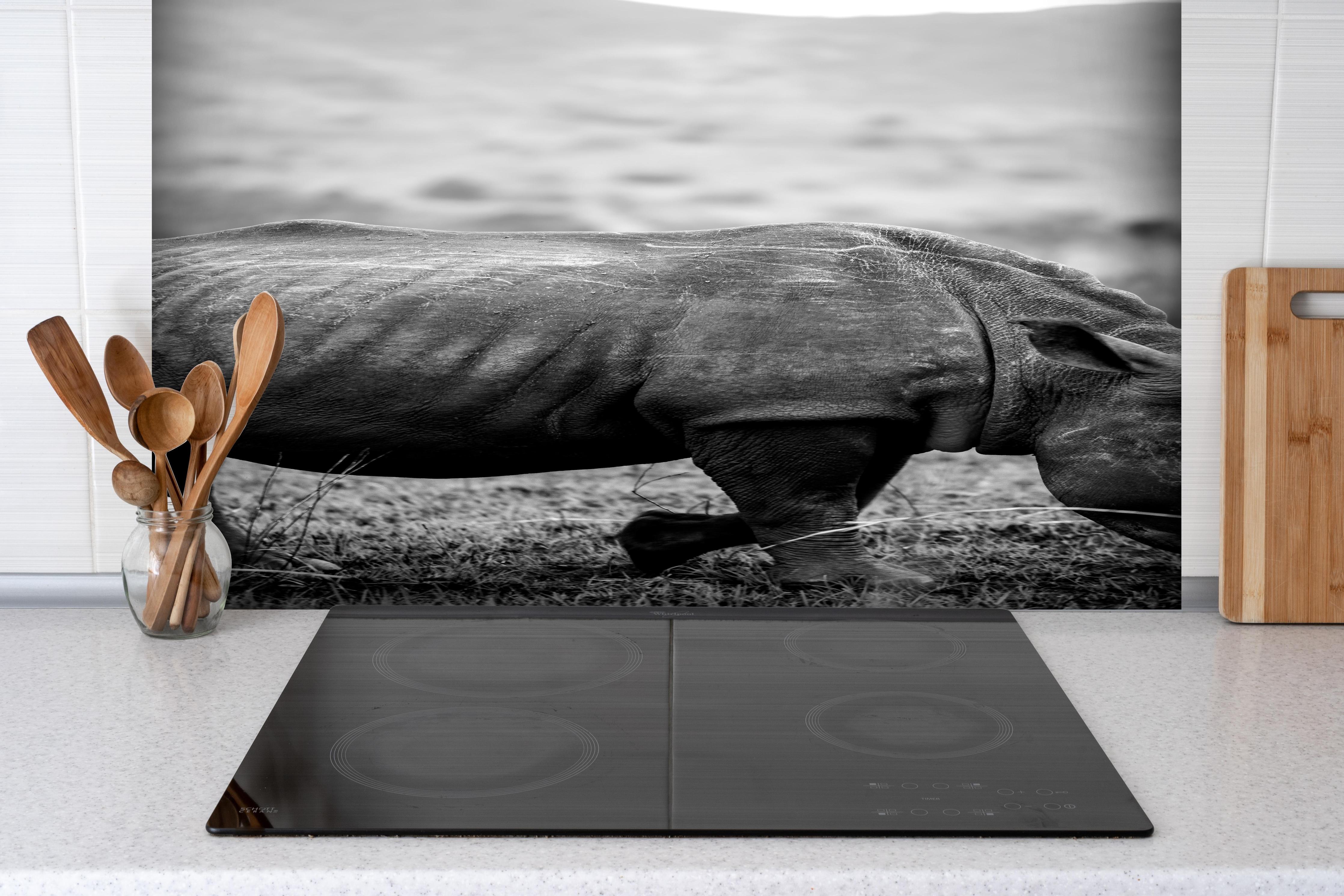 Spritzschutz - Nashorn - schwarz-weiß hinter einem Cerankochfeld zwischen Holz-Kochutensilien
