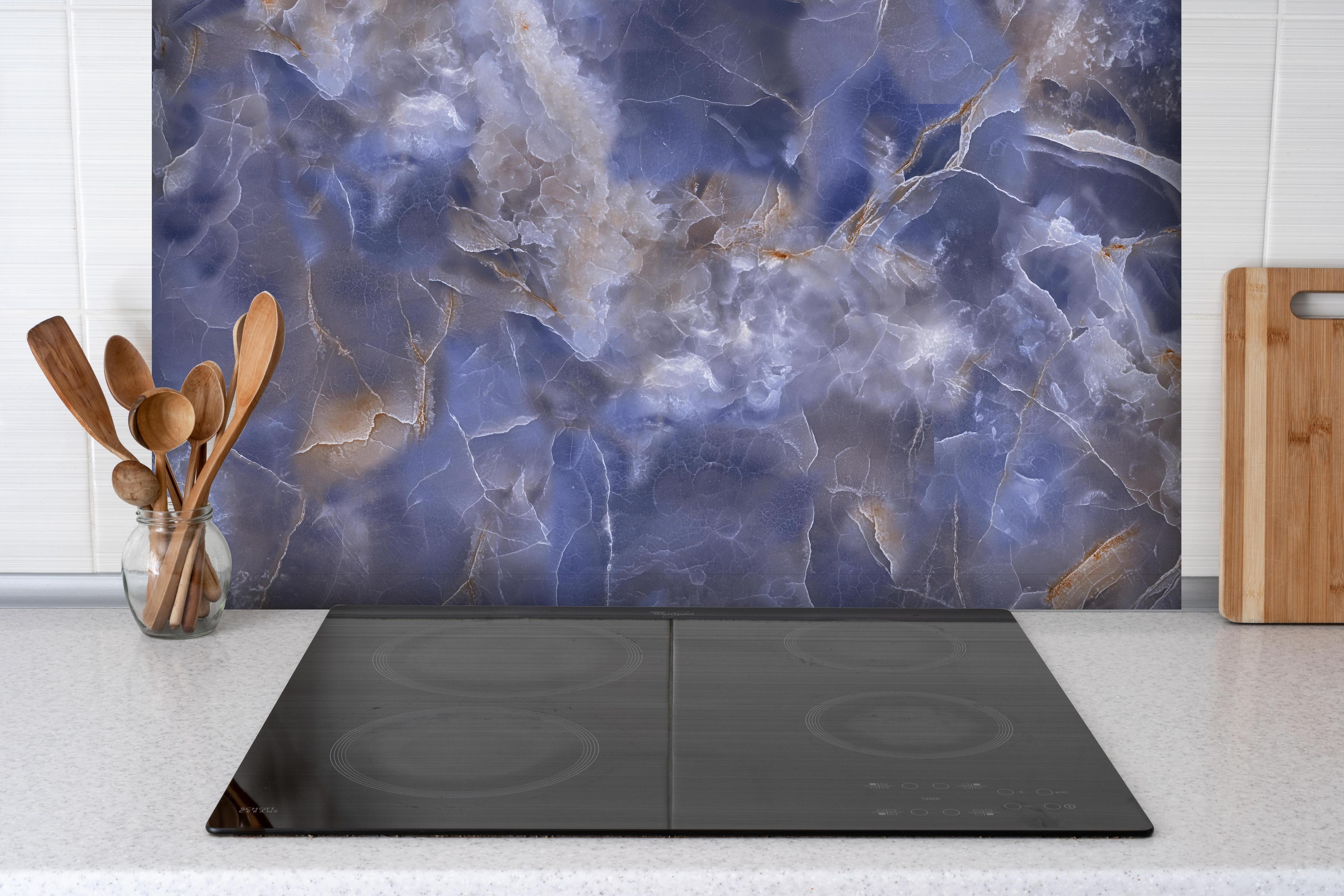 Spritzschutz - Natürlicher Onyx-Marmor hinter einem Cerankochfeld zwischen Holz-Kochutensilien
