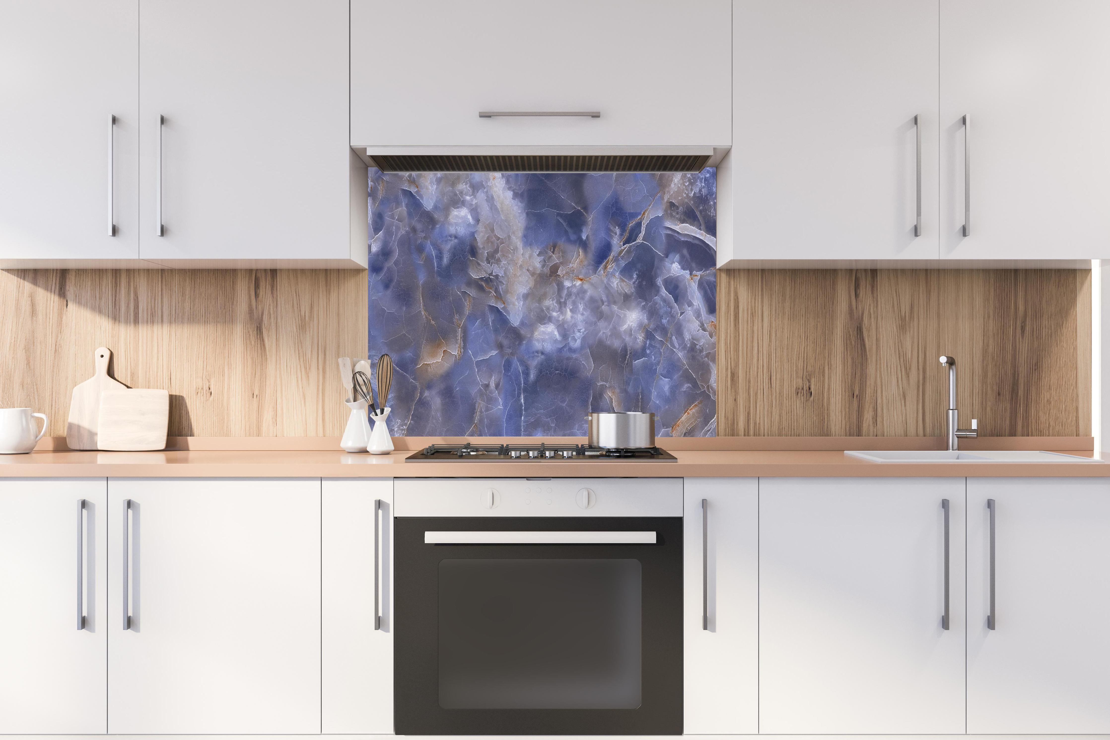 Spritzschutz - Natürlicher Onyx-Marmor hinter einem Cerankochfeld zwischen Holz-Kochutensilien
