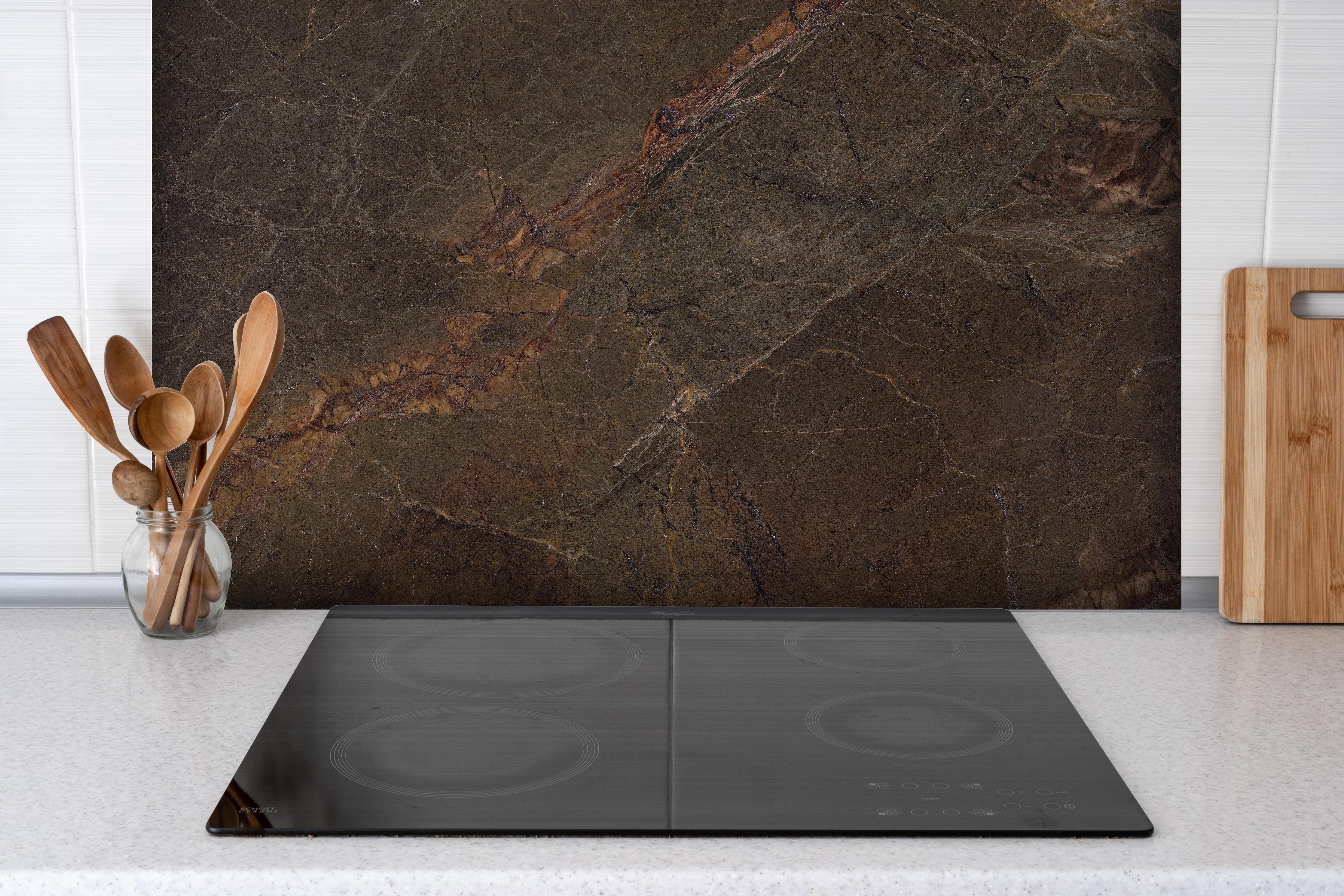 Spritzschutz - Natürliches Mamorstein Design hinter einem Cerankochfeld zwischen Holz-Kochutensilien

