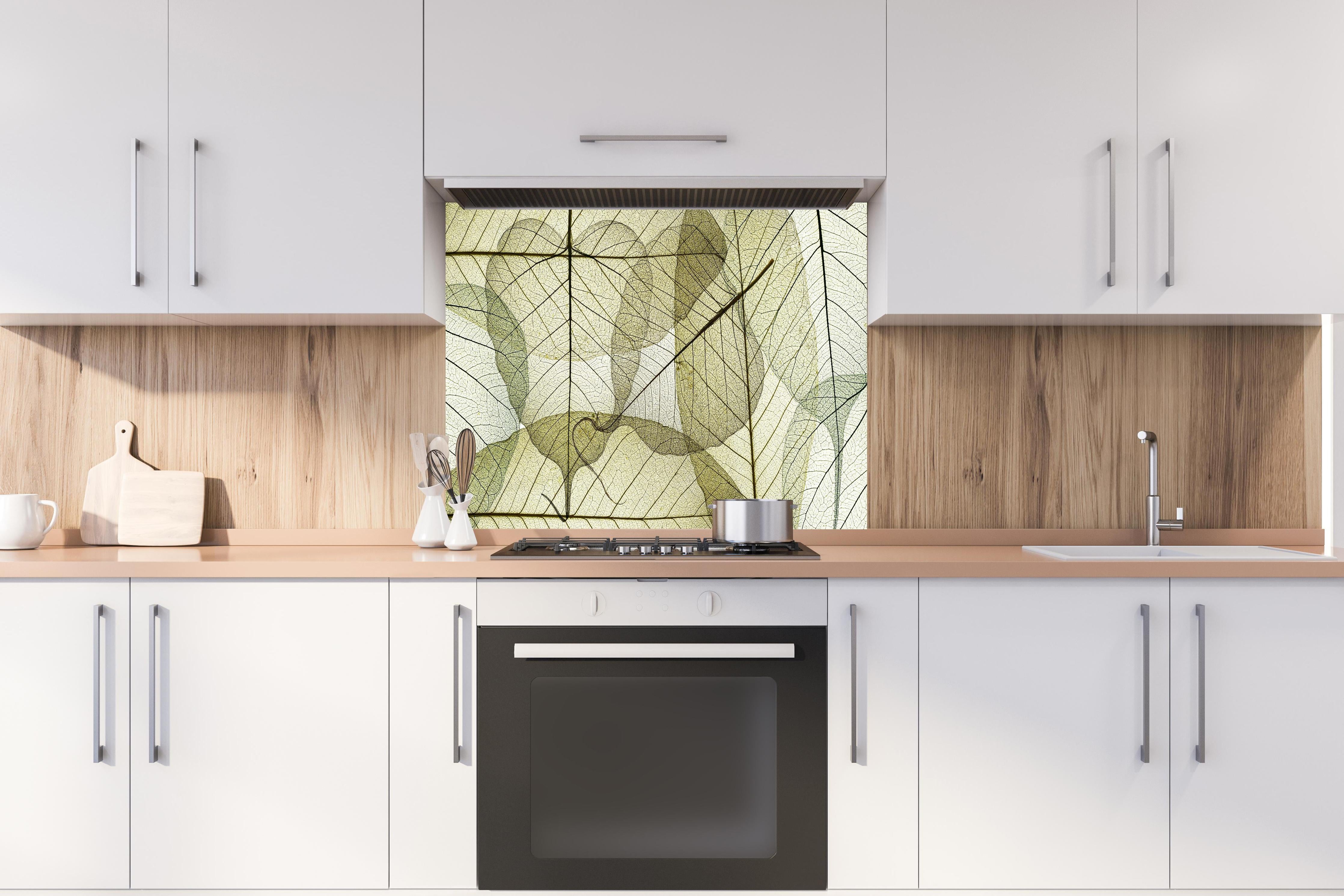 Spritzschutz - Naturinspirierte Blattmuster Texturen Beige hinter einem Cerankochfeld zwischen Holz-Kochutensilien
