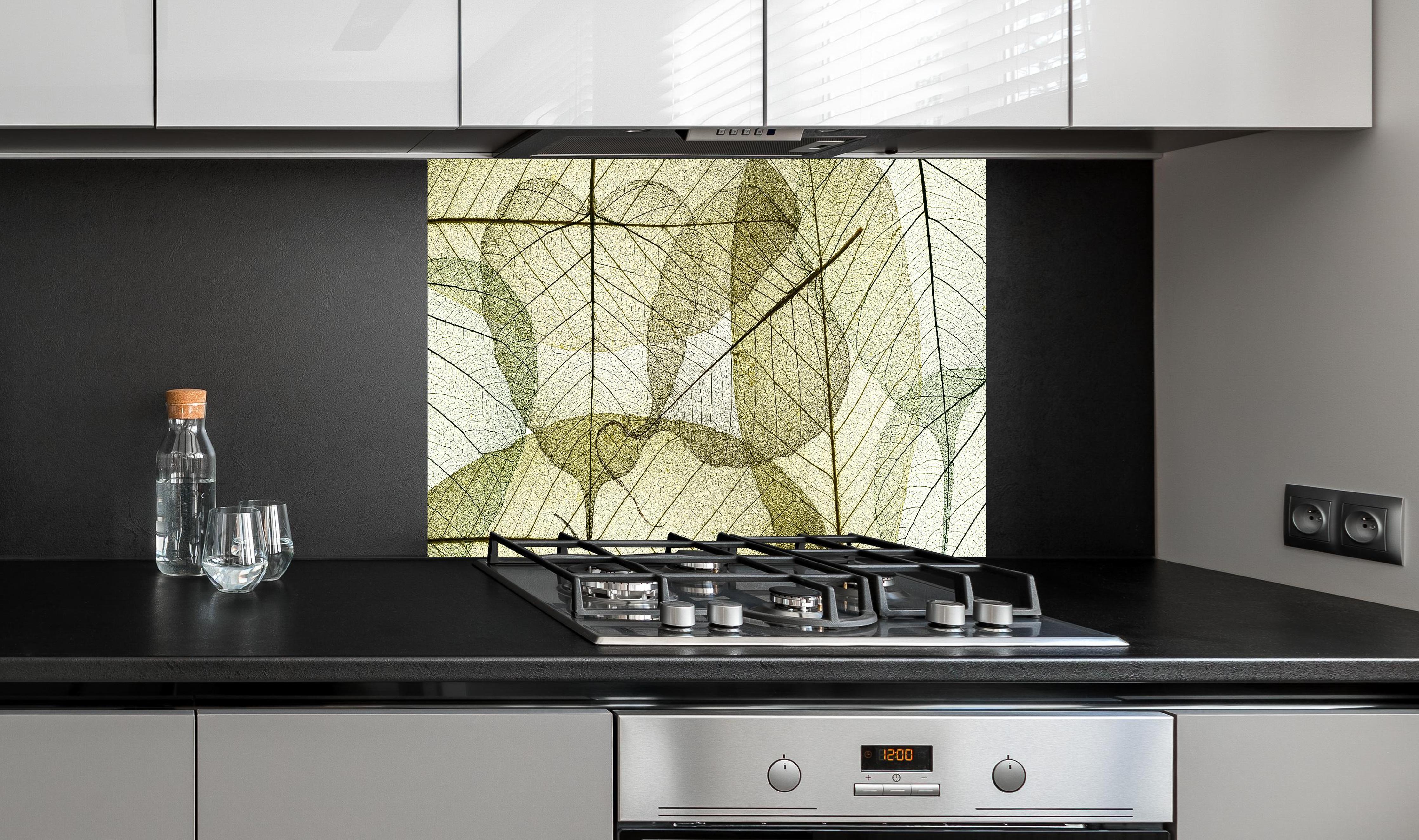 Spritzschutz - Naturinspirierte Blattmuster Texturen Beige hinter einem Cerankochfeld zwischen Holz-Kochutensilien
