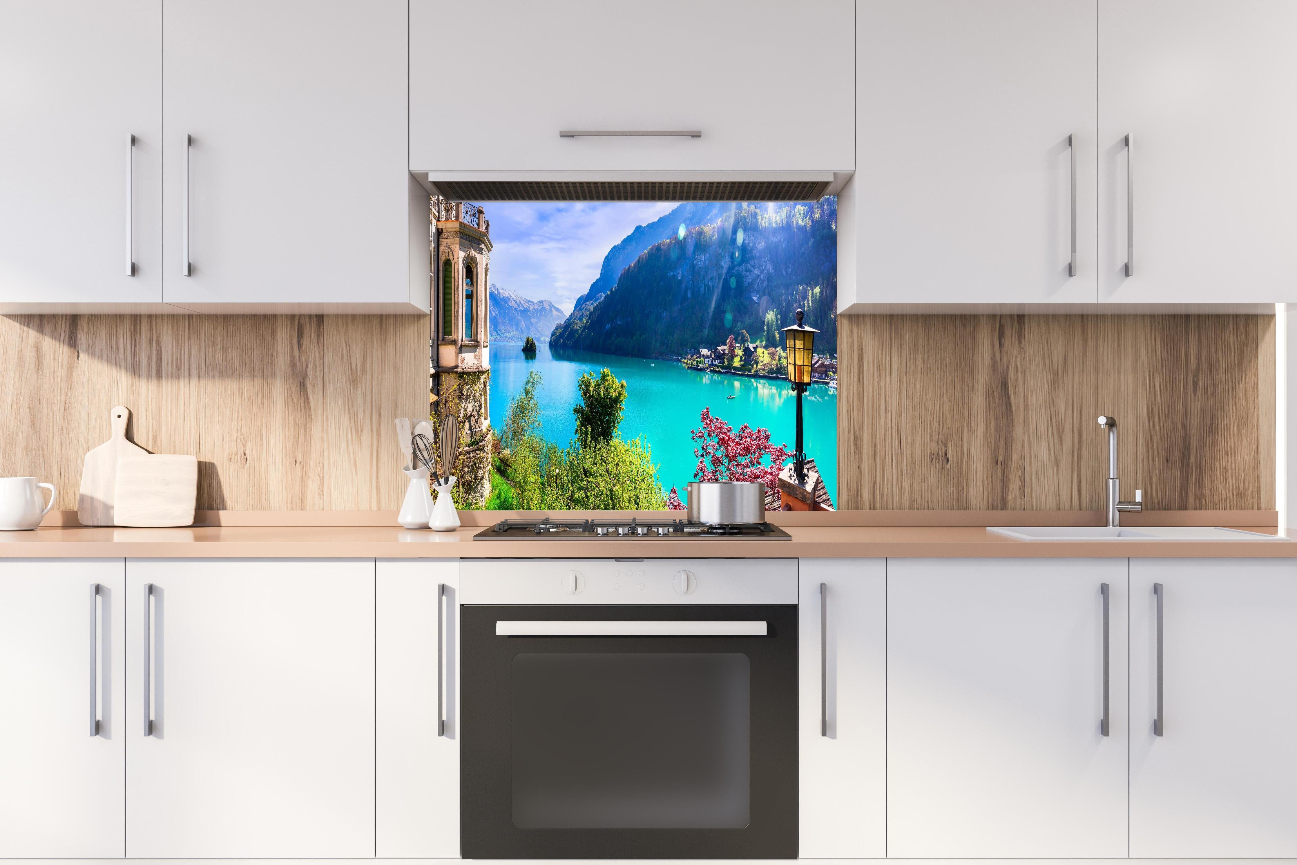 Spritzschutz - Naturkulisse des Brienzersees - Schweiz hinter einem Cerankochfeld zwischen Holz-Kochutensilien
