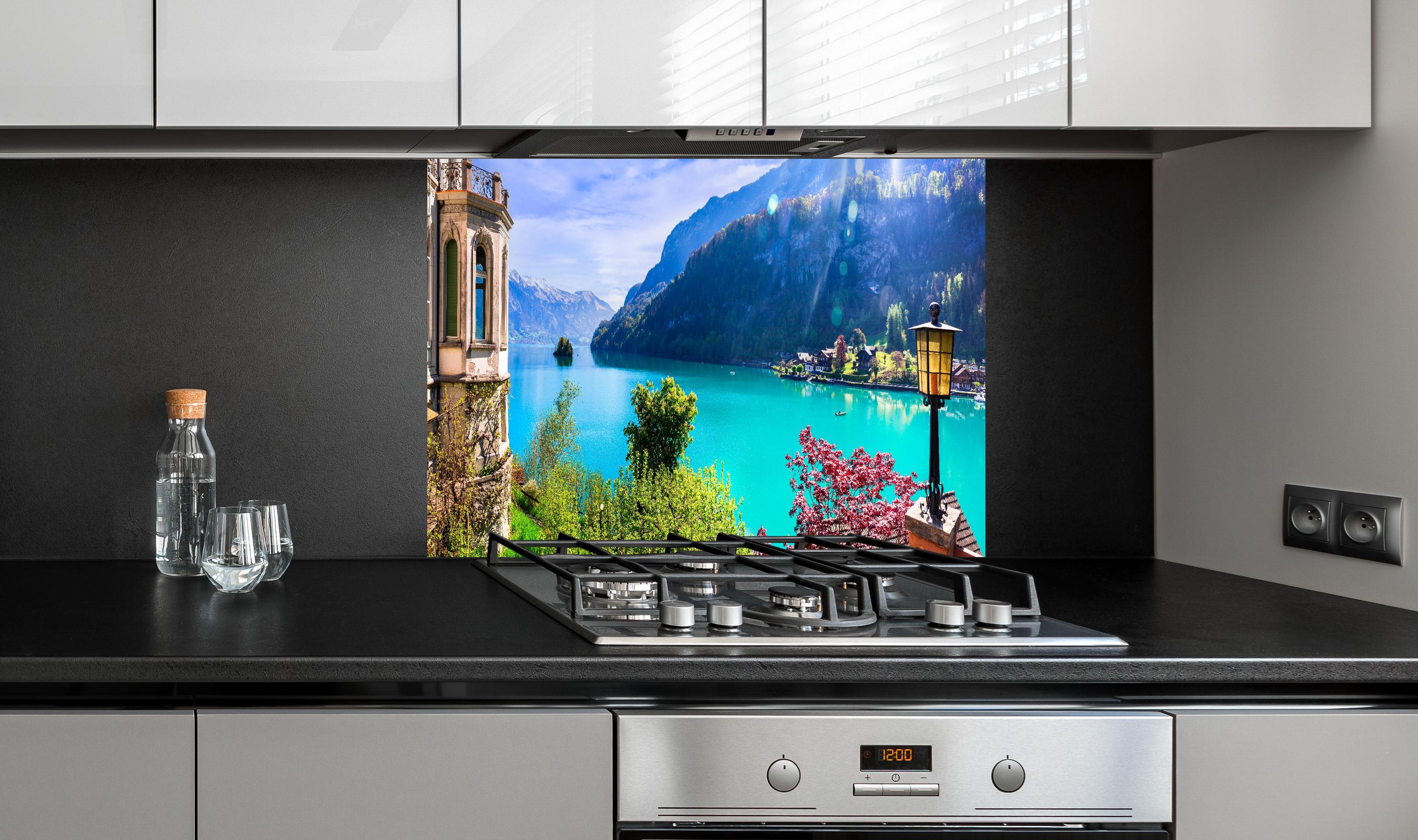 Spritzschutz - Naturkulisse des Brienzersees - Schweiz hinter einem Cerankochfeld zwischen Holz-Kochutensilien
