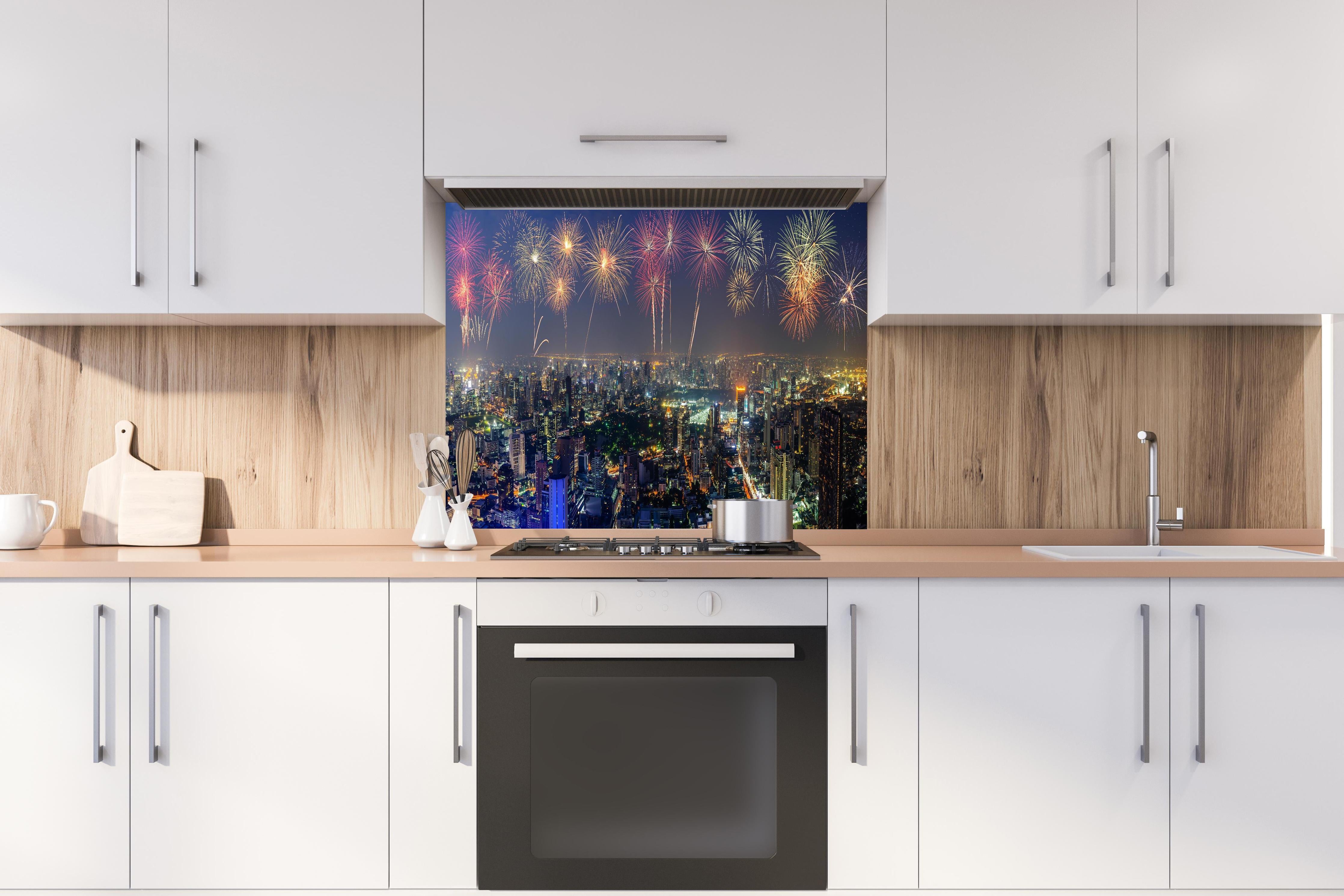 Spritzschutz - Neujahres Skyline in Bangkok hinter einem Cerankochfeld zwischen Holz-Kochutensilien
