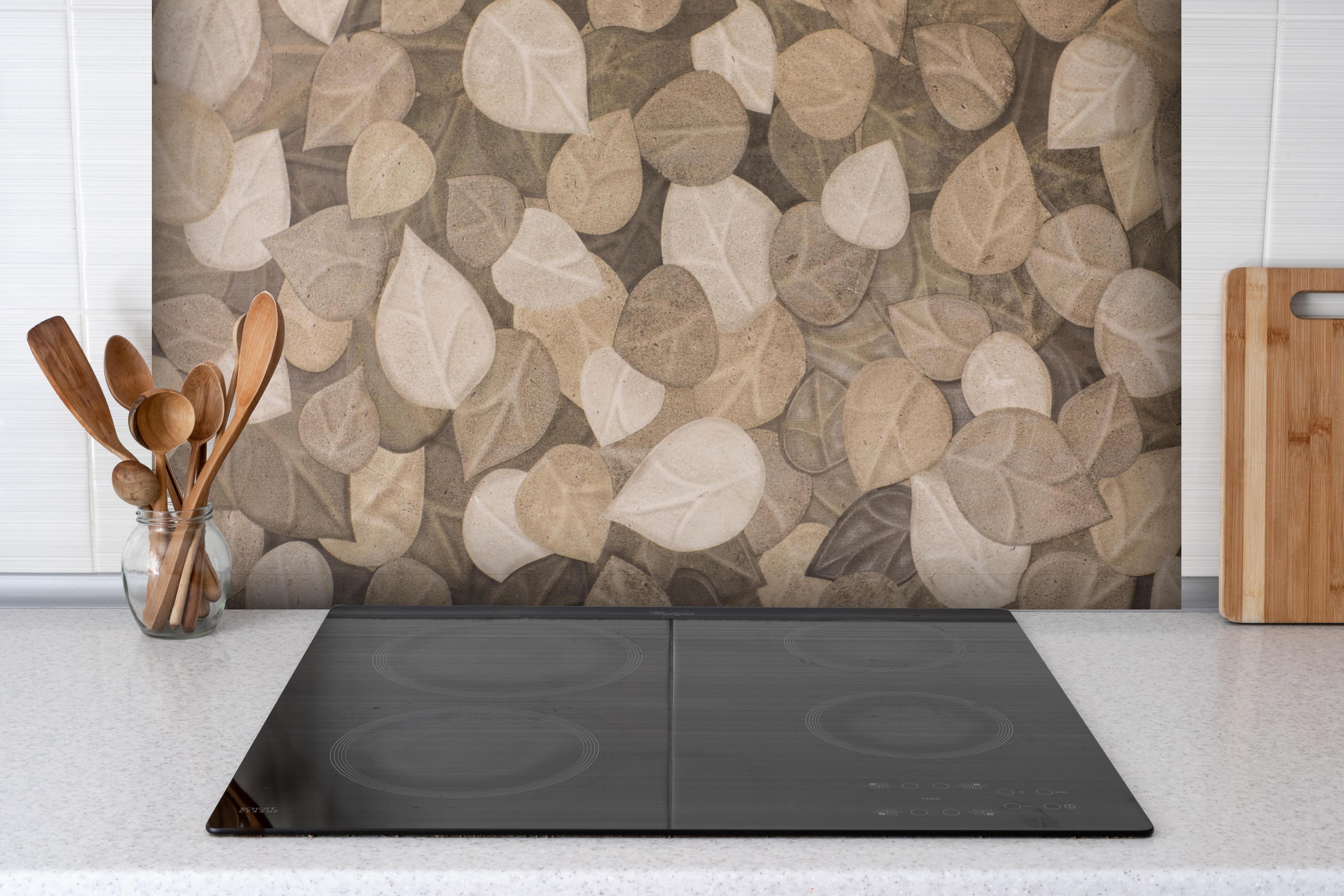 Spritzschutz - Neutrale Blattmuster Wand Tapete in Grau-Braun hinter einem Cerankochfeld zwischen Holz-Kochutensilien
