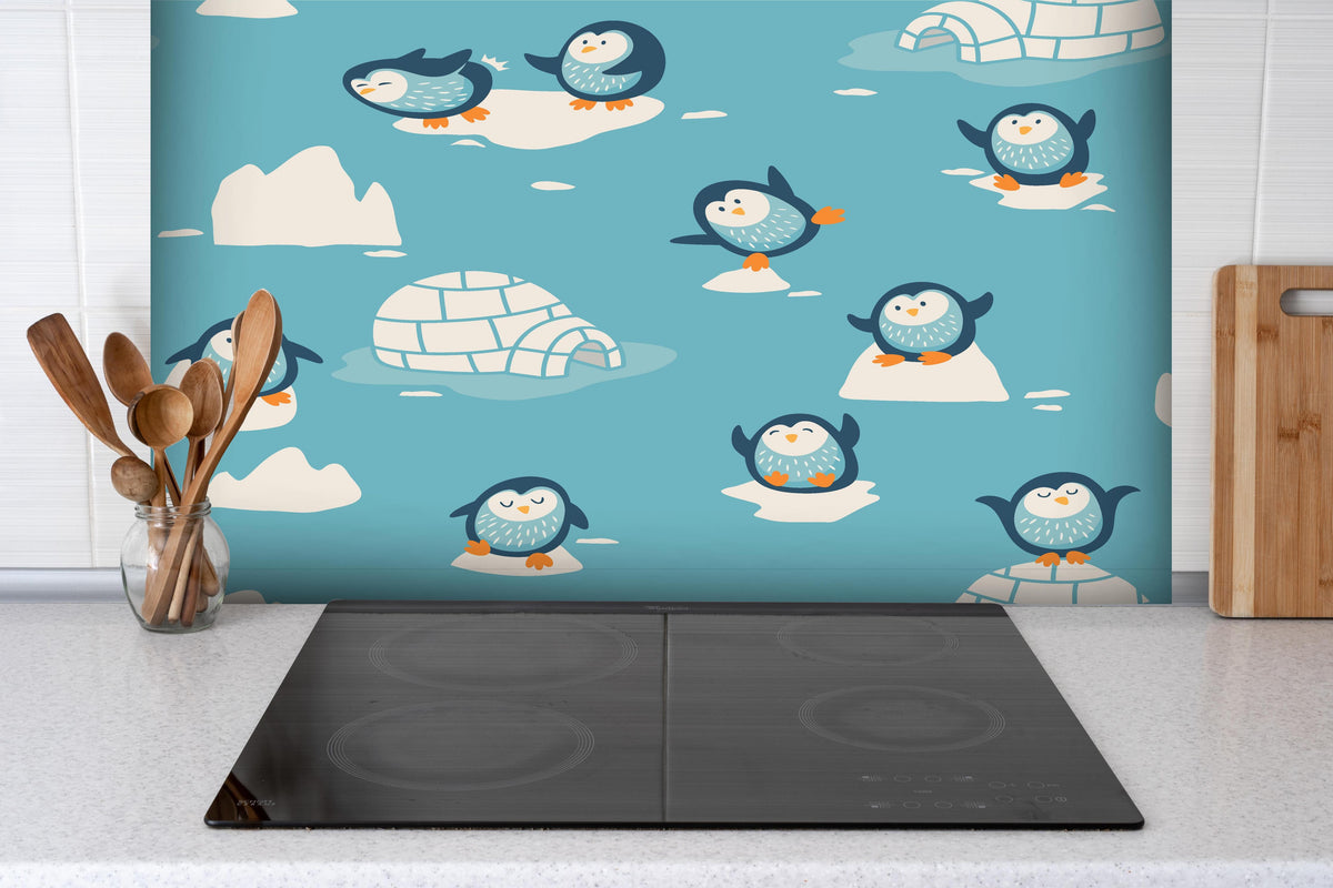 Spritzschutz - Niedliche Pinguin-Muster Kinderzimmer Dekor hinter einem Cerankochfeld zwischen Holz-Kochutensilien
