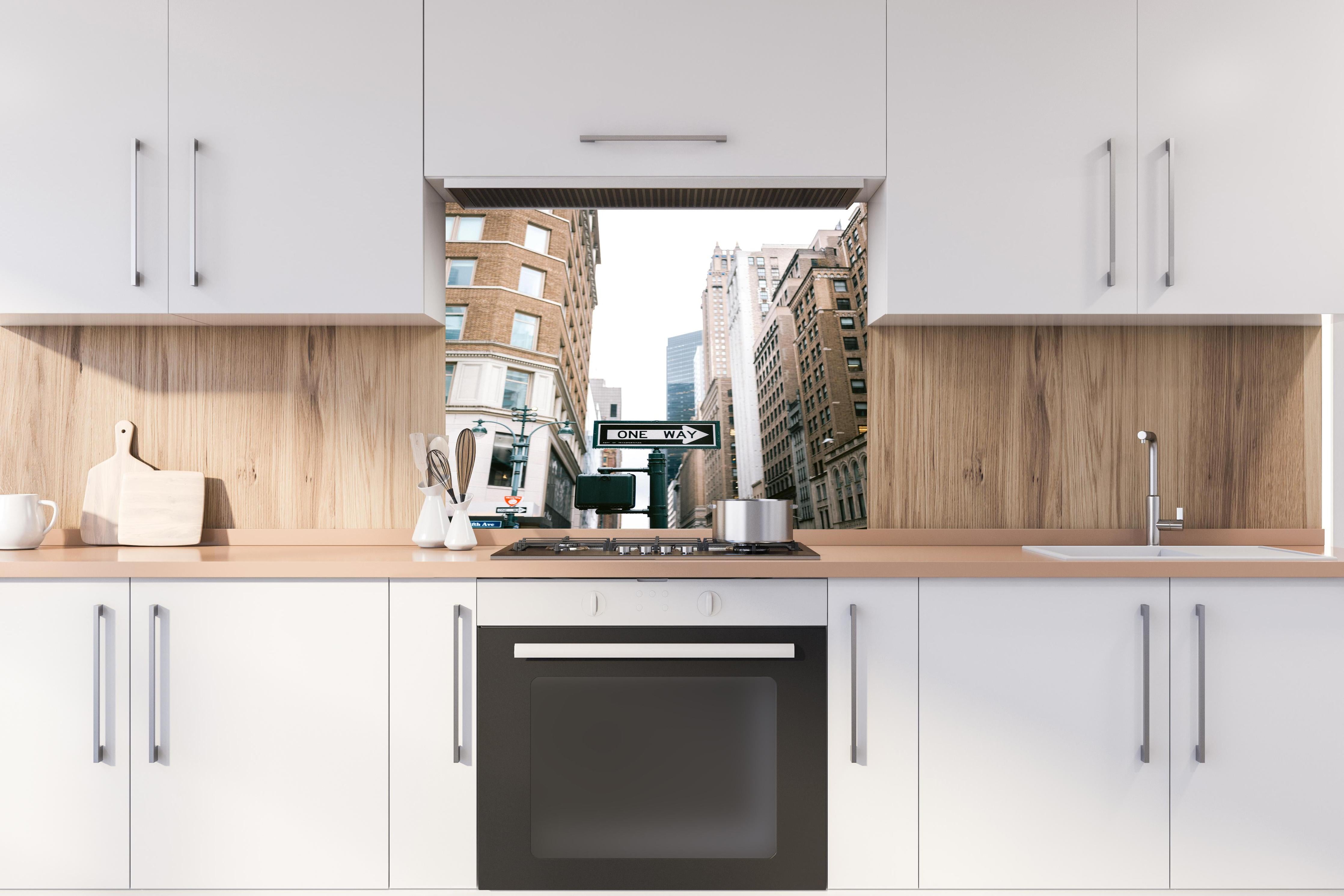 Spritzschutz - One Way Schild Fifth Avenue NYC hinter einem Cerankochfeld zwischen Holz-Kochutensilien
