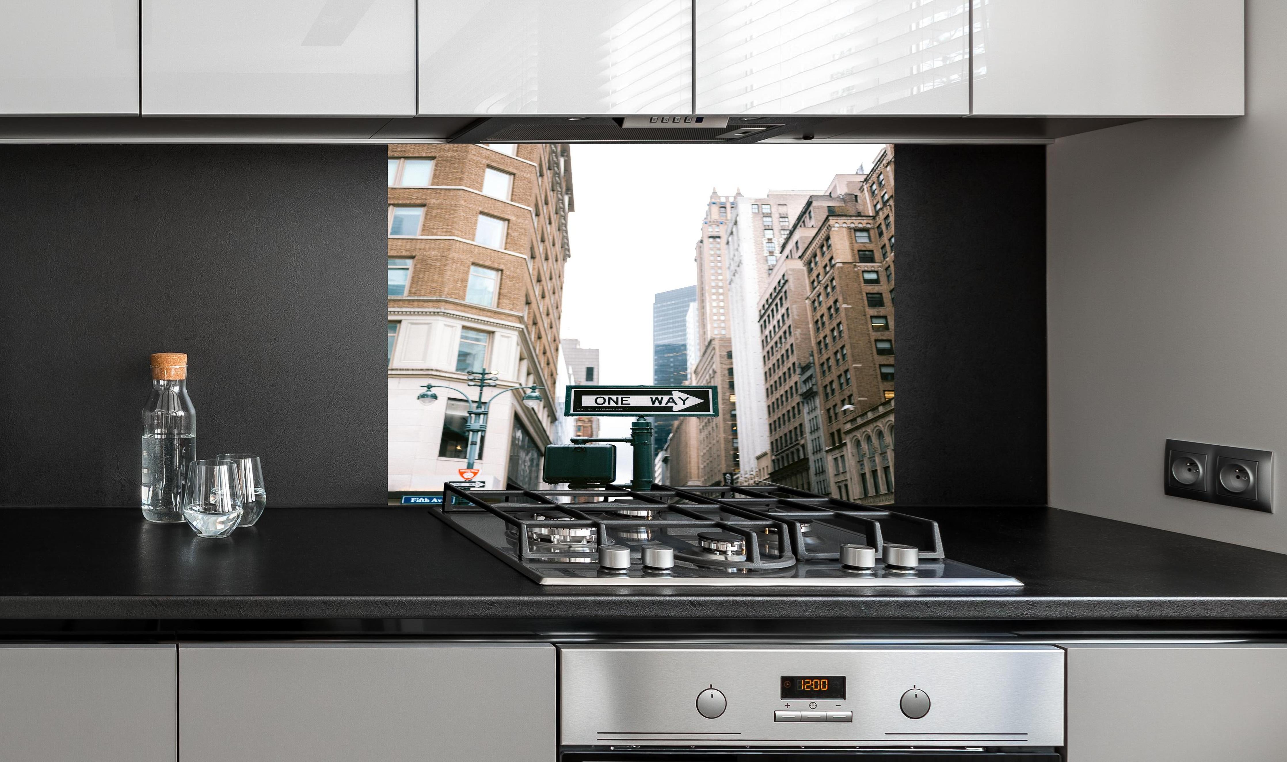 Spritzschutz - One Way Schild Fifth Avenue NYC hinter einem Cerankochfeld zwischen Holz-Kochutensilien
