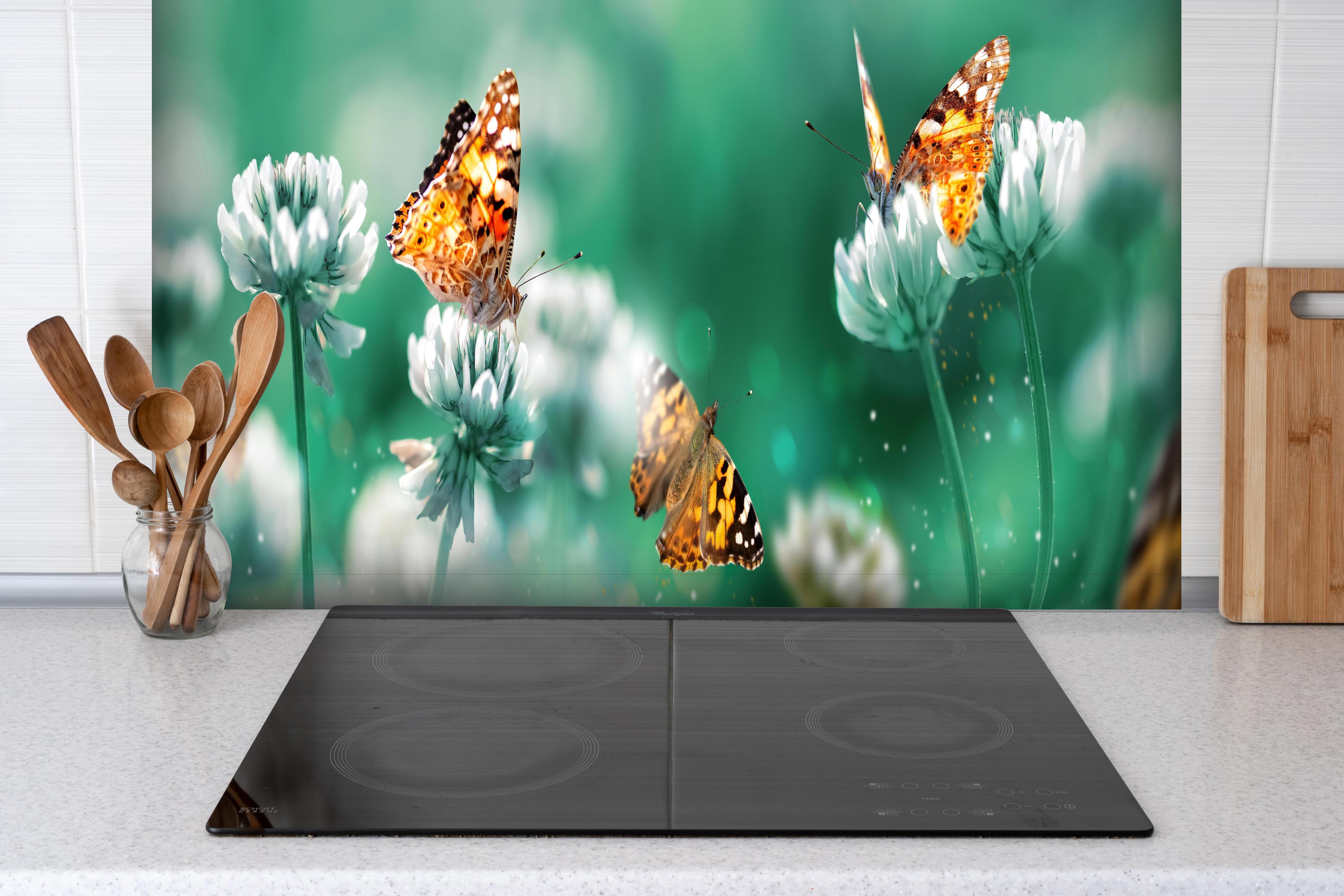 Spritzschutz - Orange Schmetterlinge Sommergarten hinter einem Cerankochfeld zwischen Holz-Kochutensilien
