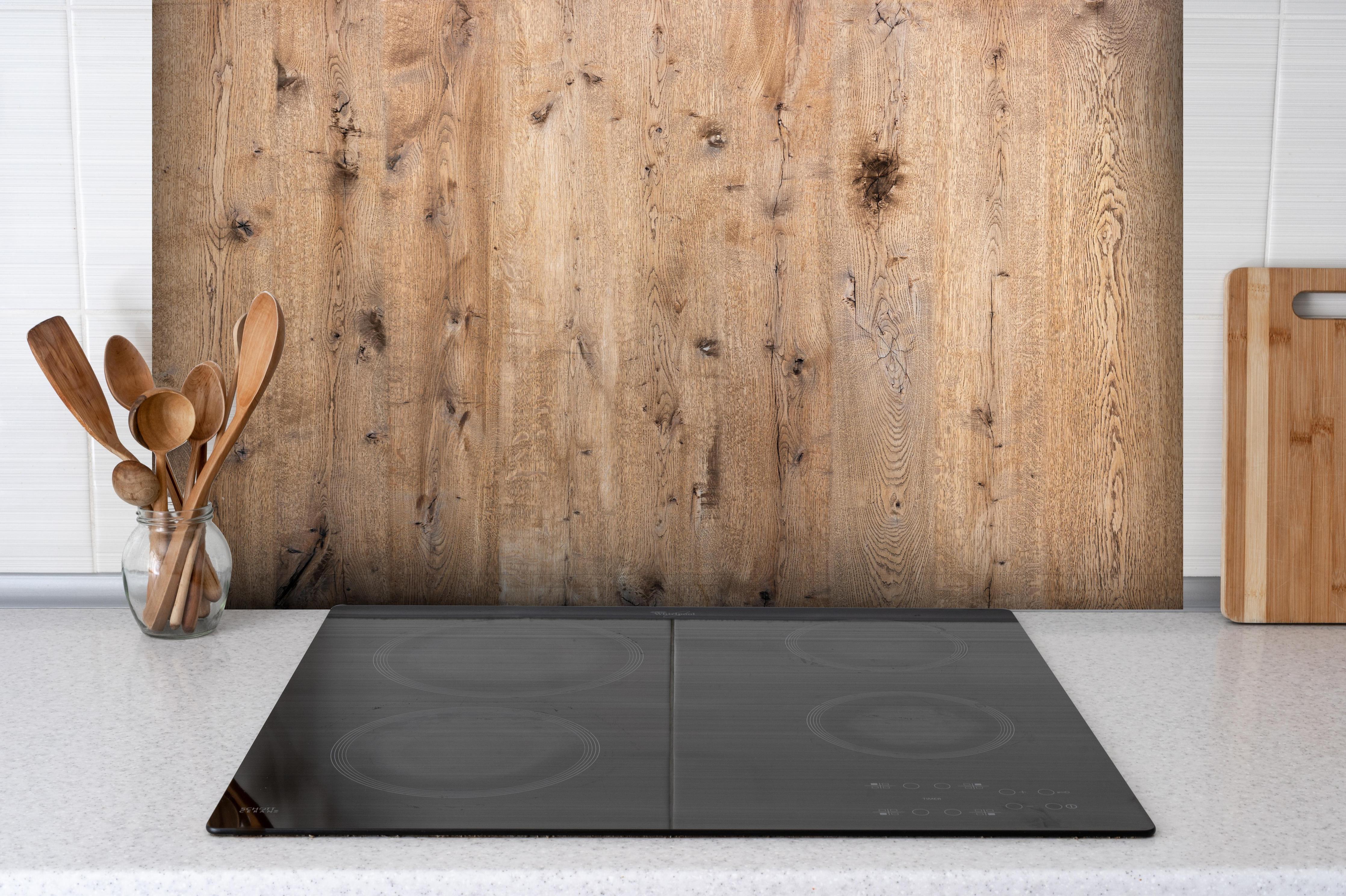 Spritzschutz - Organische Eichenholz-Struktur hinter einem Cerankochfeld zwischen Holz-Kochutensilien
