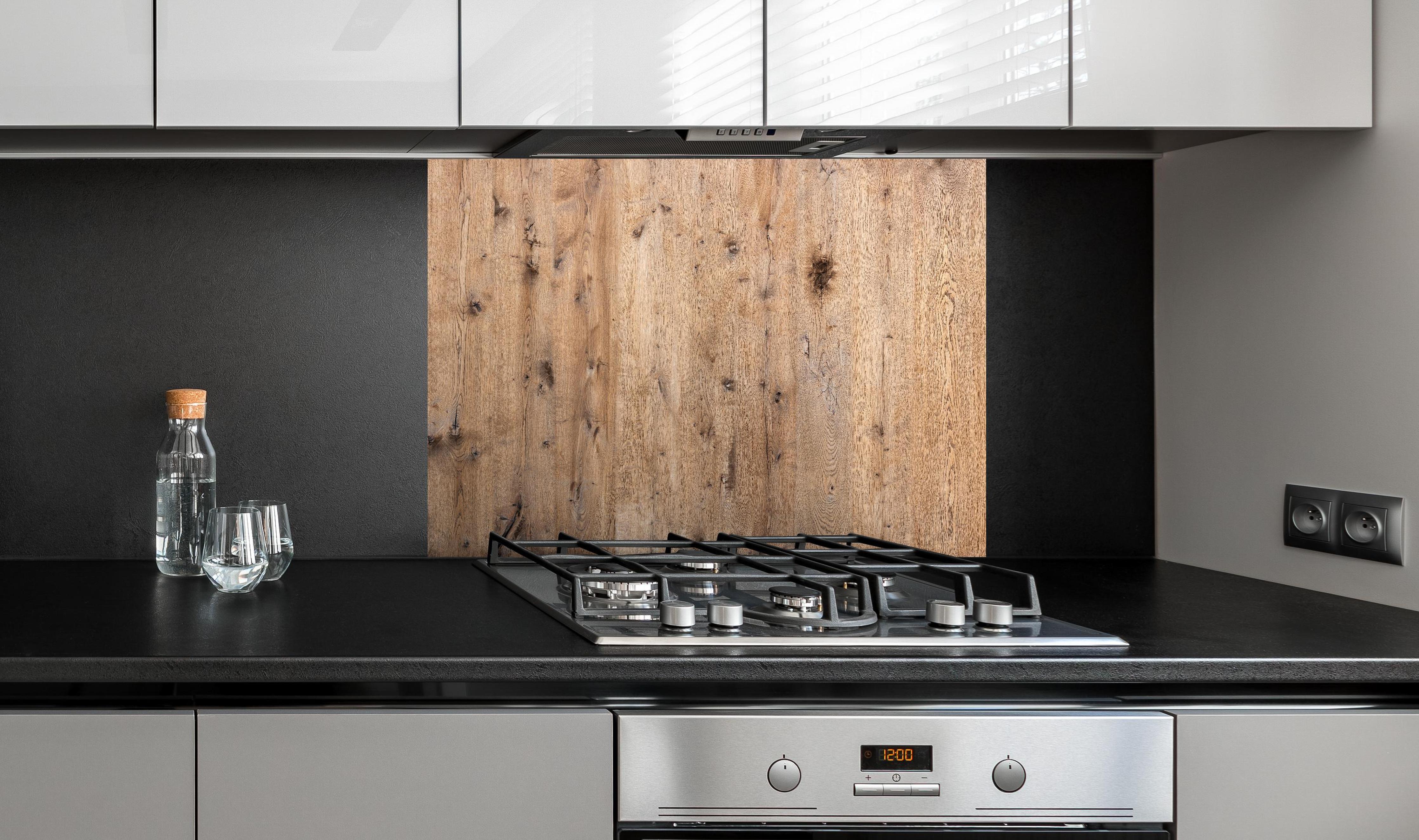 Spritzschutz - Organische Eichenholz-Struktur hinter einem Cerankochfeld zwischen Holz-Kochutensilien
