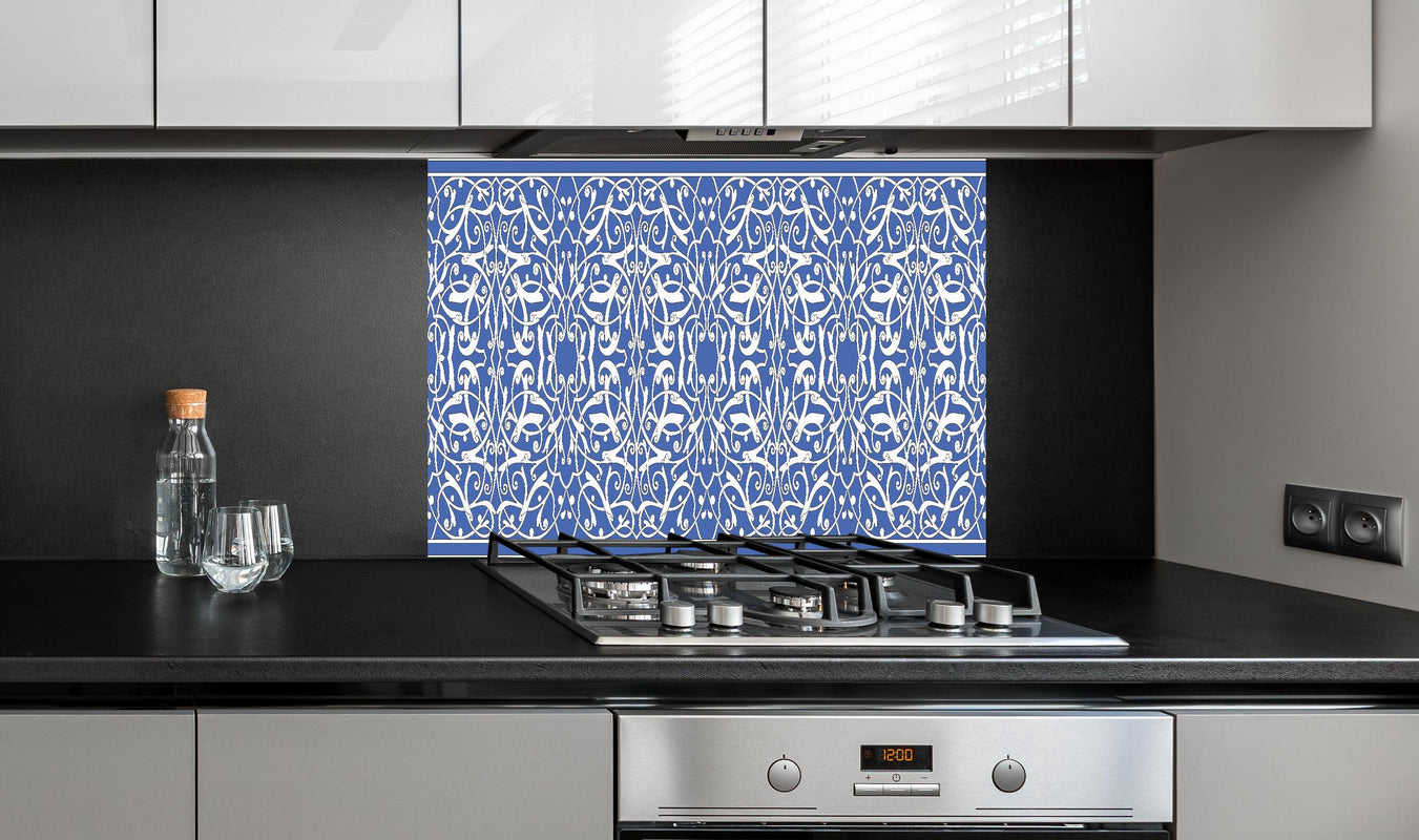 Spritzschutz - Orientalisches Blau-weiß Designmuster hinter einem Cerankochfeld zwischen Holz-Kochutensilien
