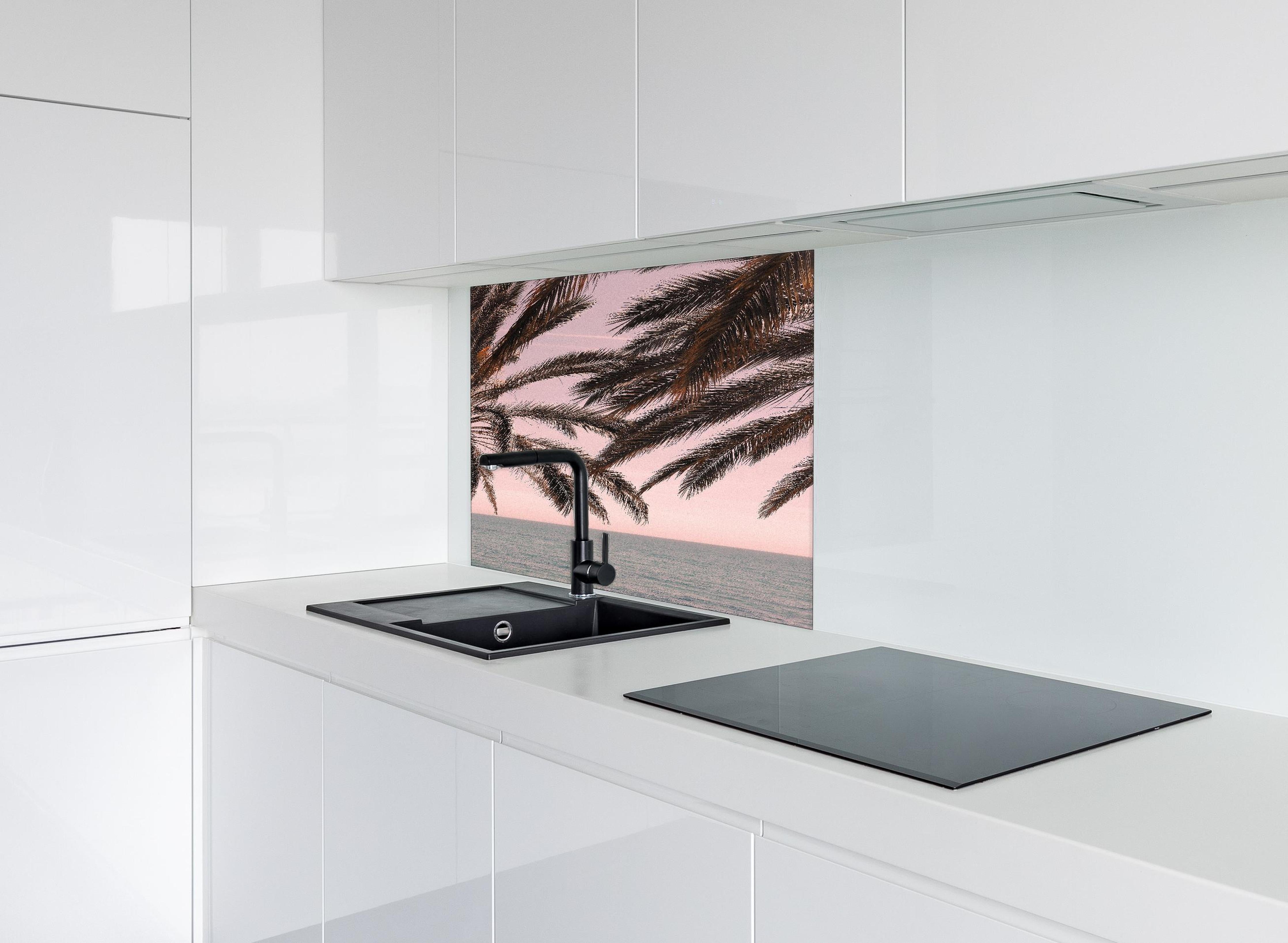 Spritzschutz - Palmen an der Küste hinter einem Cerankochfeld zwischen Holz-Kochutensilien
