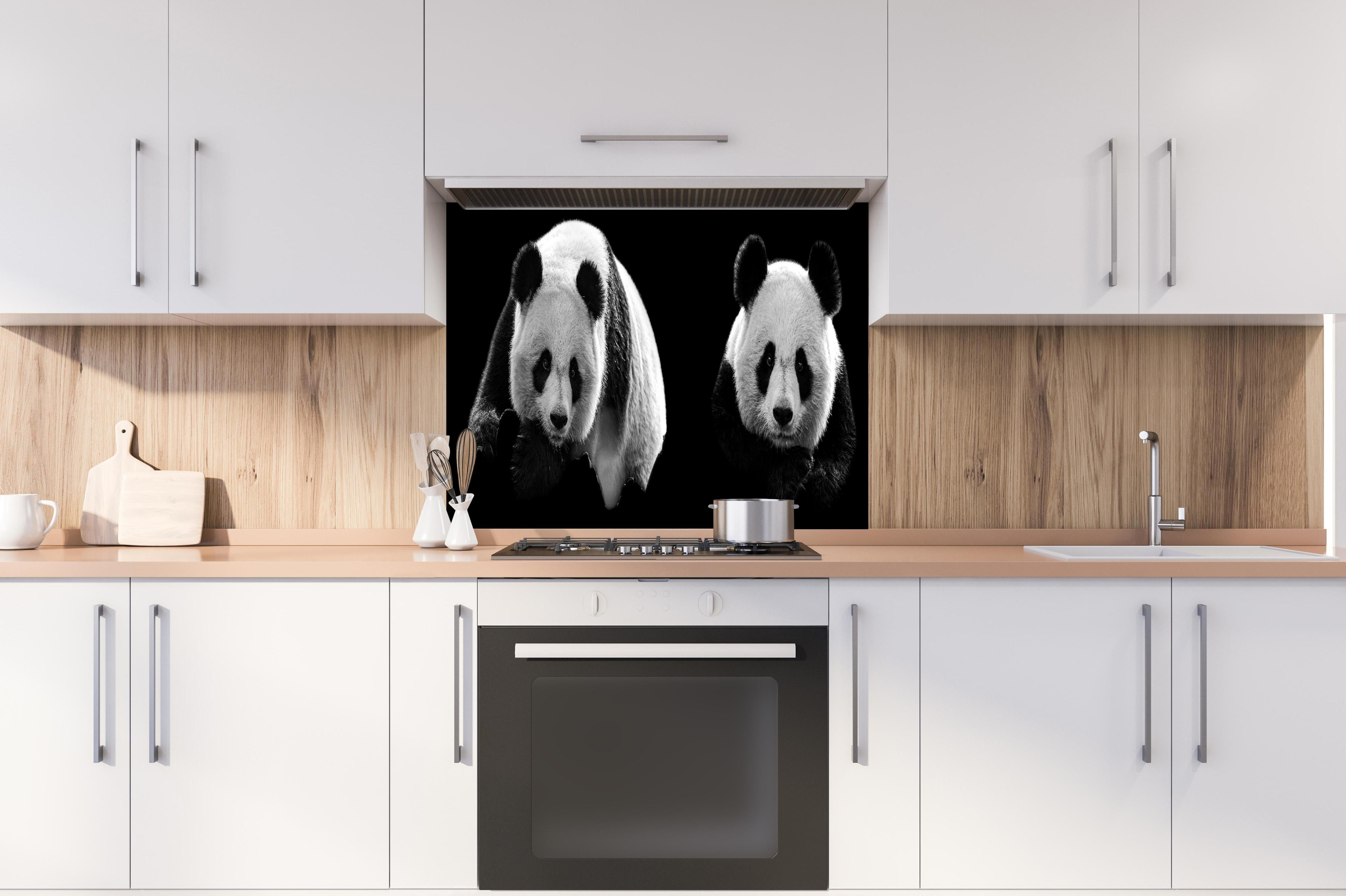 Spritzschutz - Panda mit schwarzem Hintergrund hinter einem Cerankochfeld zwischen Holz-Kochutensilien
