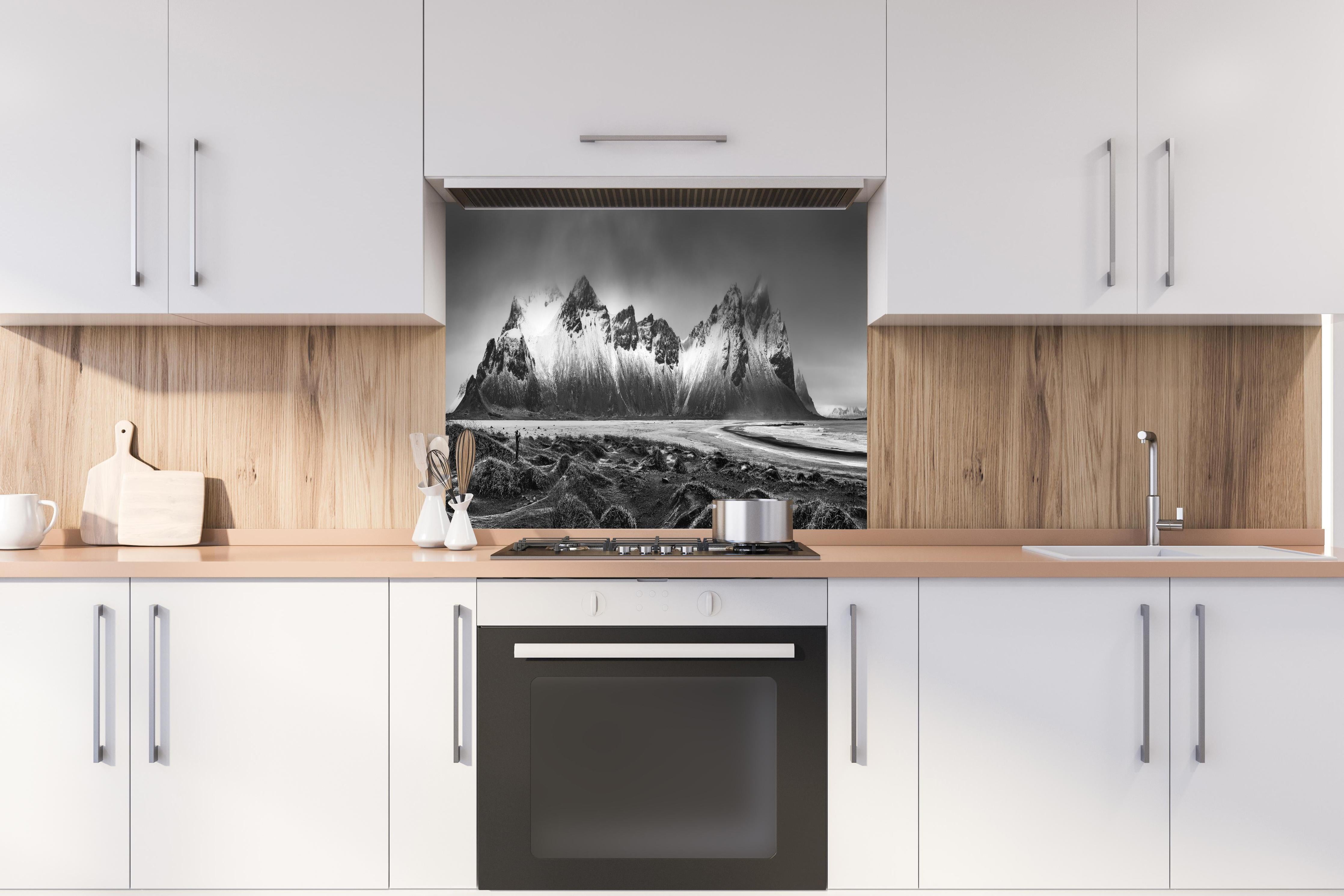 Spritzschutz - Panorama - Bergkette Vestrahorn hinter einem Cerankochfeld zwischen Holz-Kochutensilien
