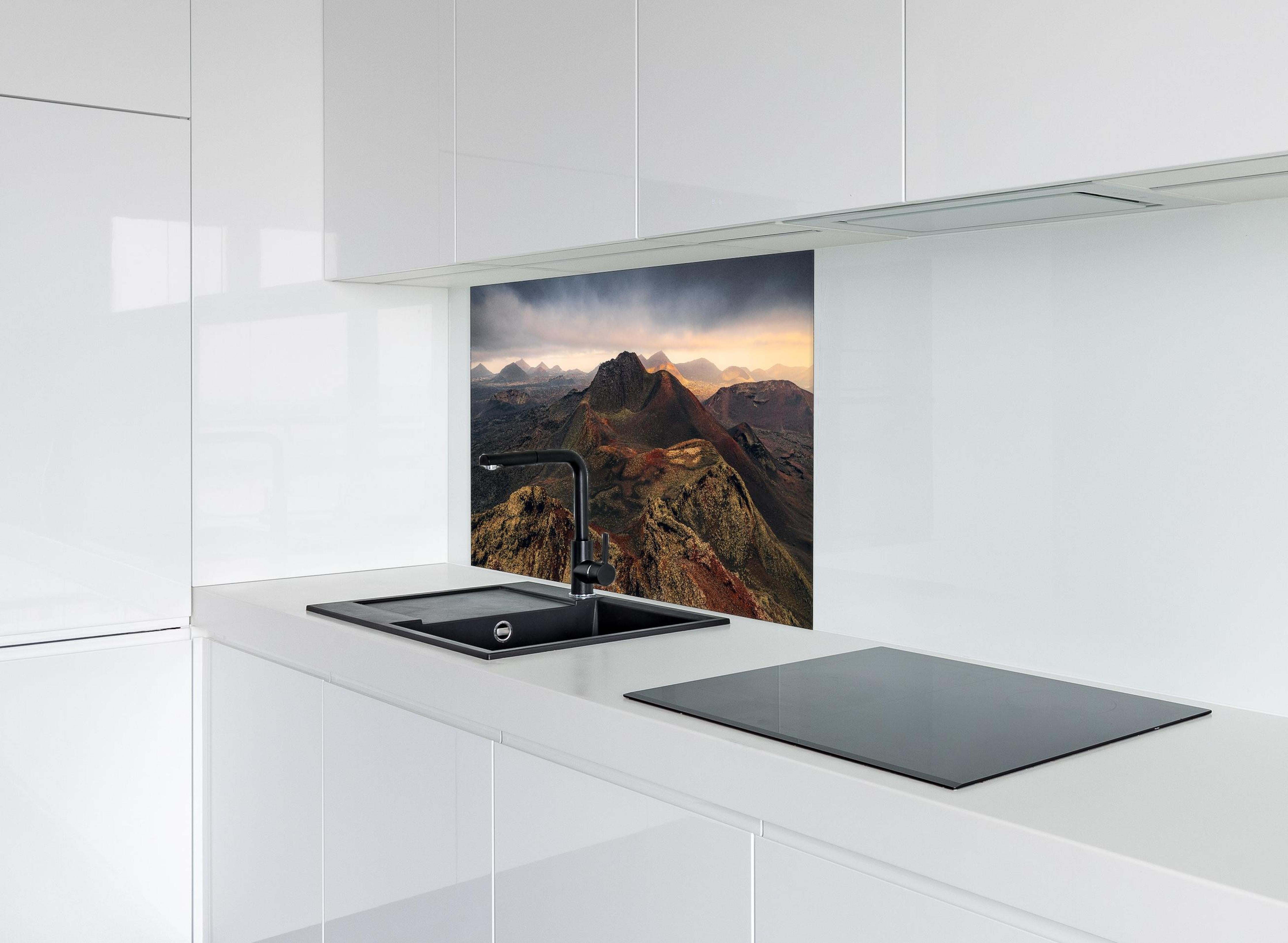 Spritzschutz - Panorama Vulkanberge unter dramatischem Himmel hinter einem Cerankochfeld zwischen Holz-Kochutensilien
