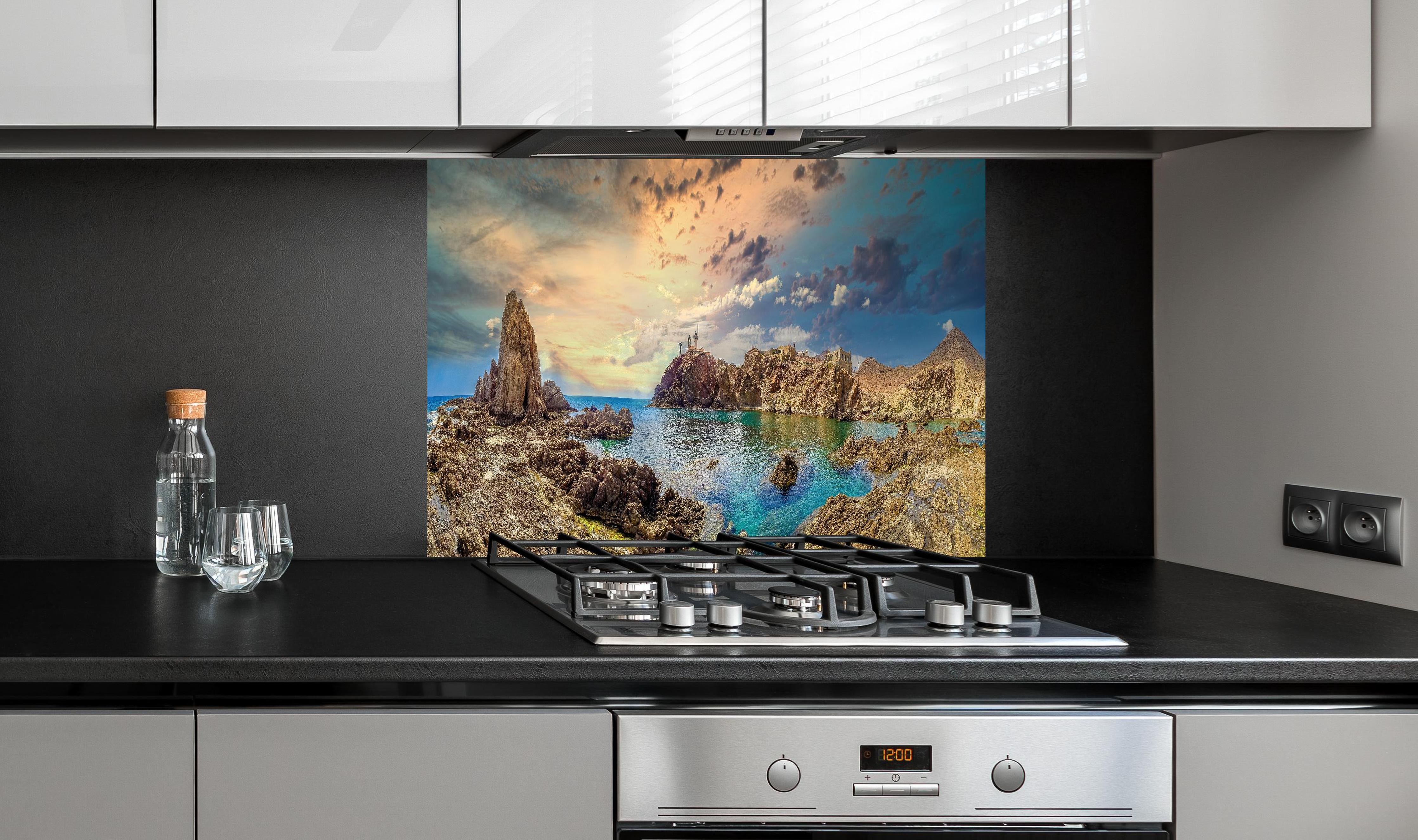 Spritzschutz - Panoramablick - Arrecife de las Sirenas hinter einem Cerankochfeld zwischen Holz-Kochutensilien
