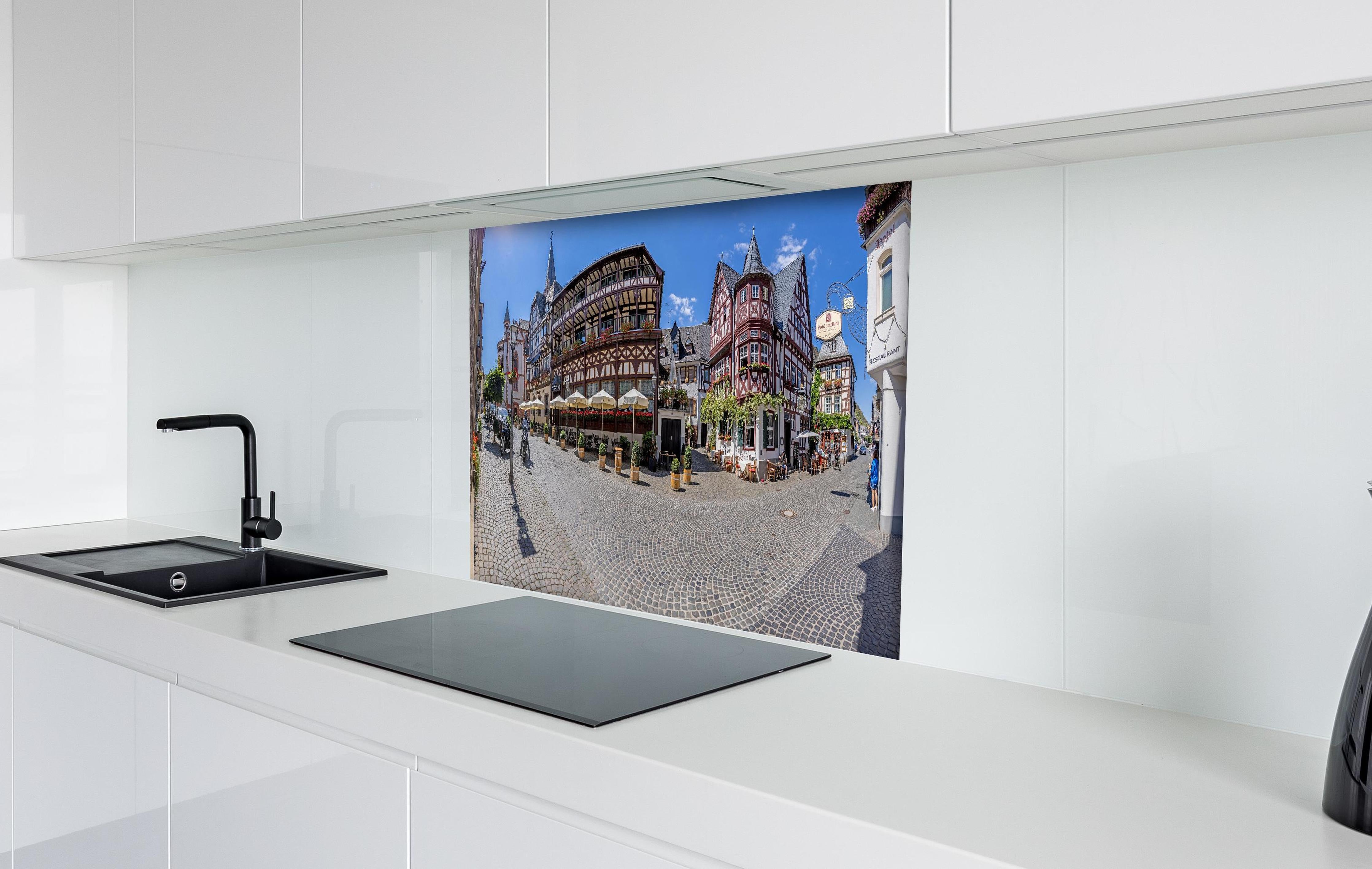 Spritzschutz - Panoramablick über Bacharach hinter einem Cerankochfeld zwischen Holz-Kochutensilien
