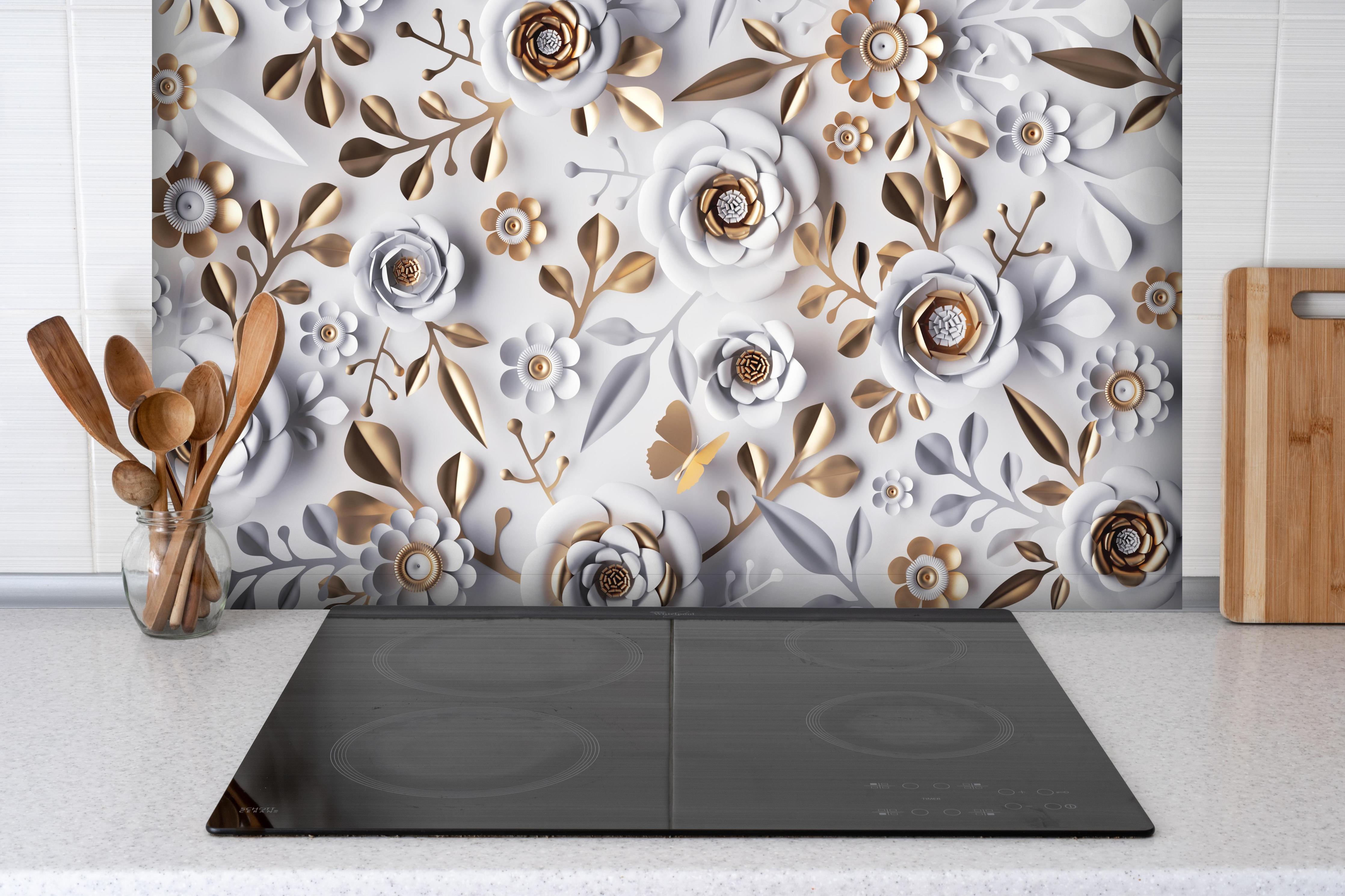 Spritzschutz - Papierblumen Hintergrund in Weiß und Gold hinter einem Cerankochfeld zwischen Holz-Kochutensilien
