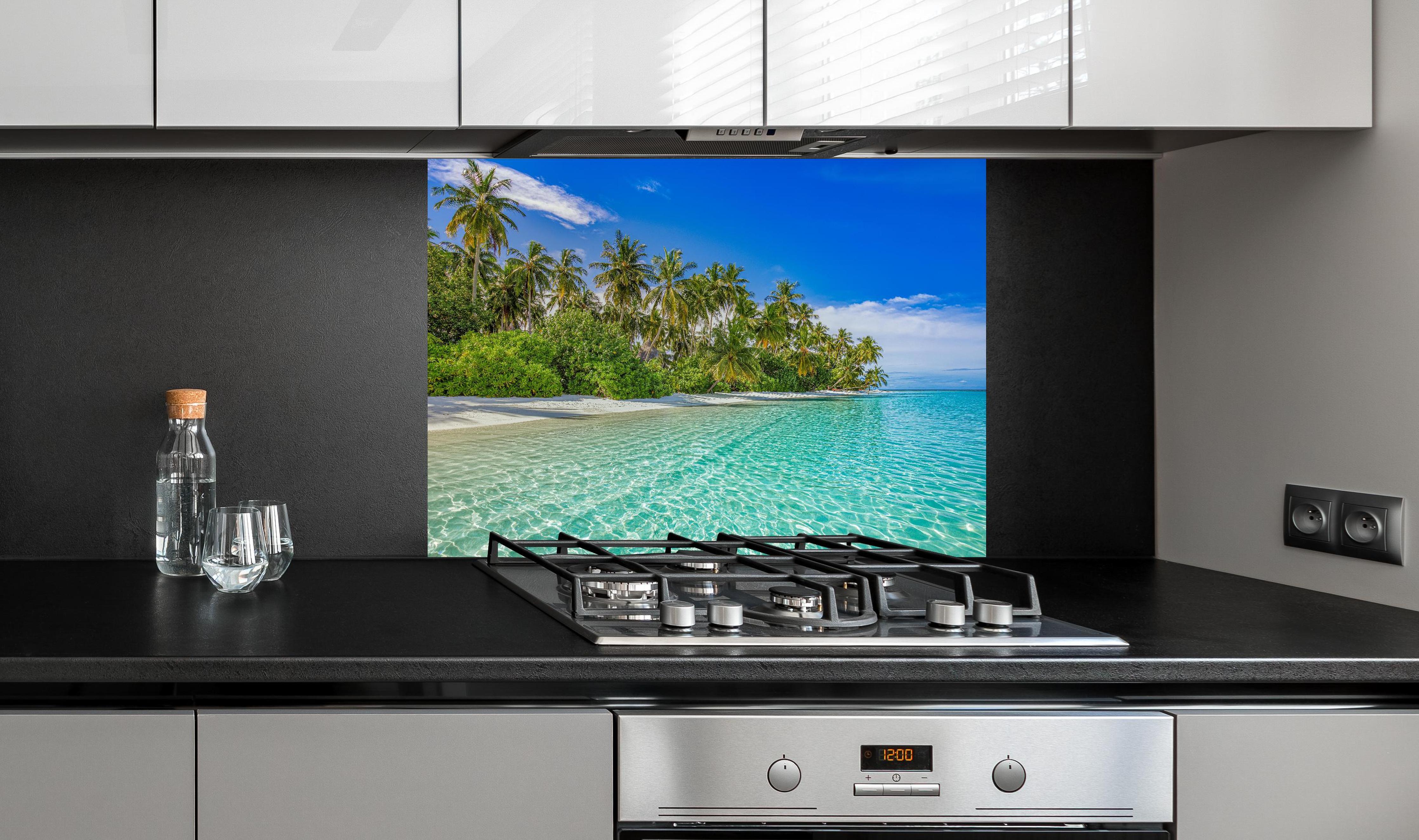 Spritzschutz - Paradiesische Insel hinter einem Cerankochfeld zwischen Holz-Kochutensilien
