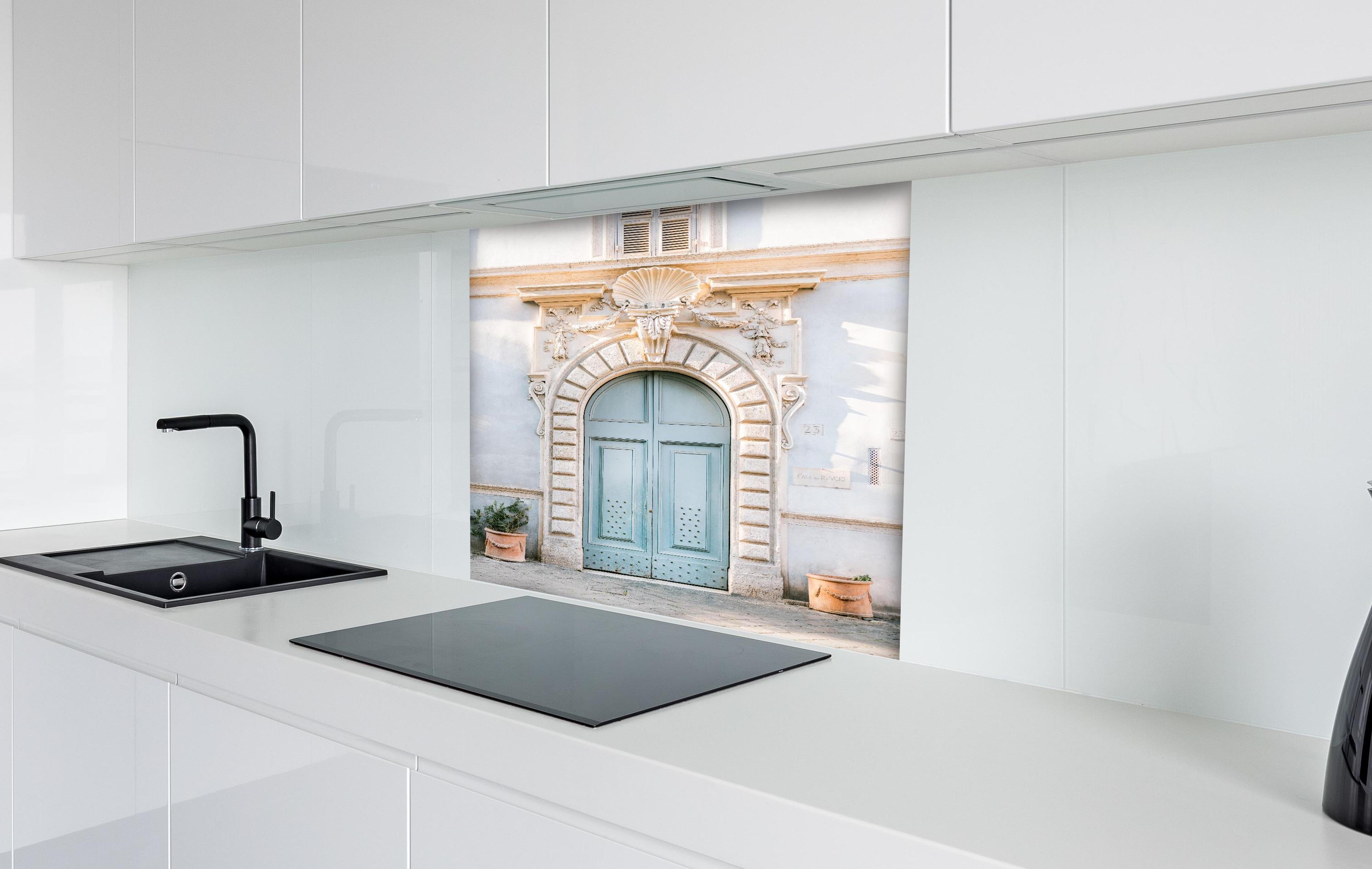 Spritzschutz - Pastellblauer Eingang römische Architektur hinter einem Cerankochfeld zwischen Holz-Kochutensilien
