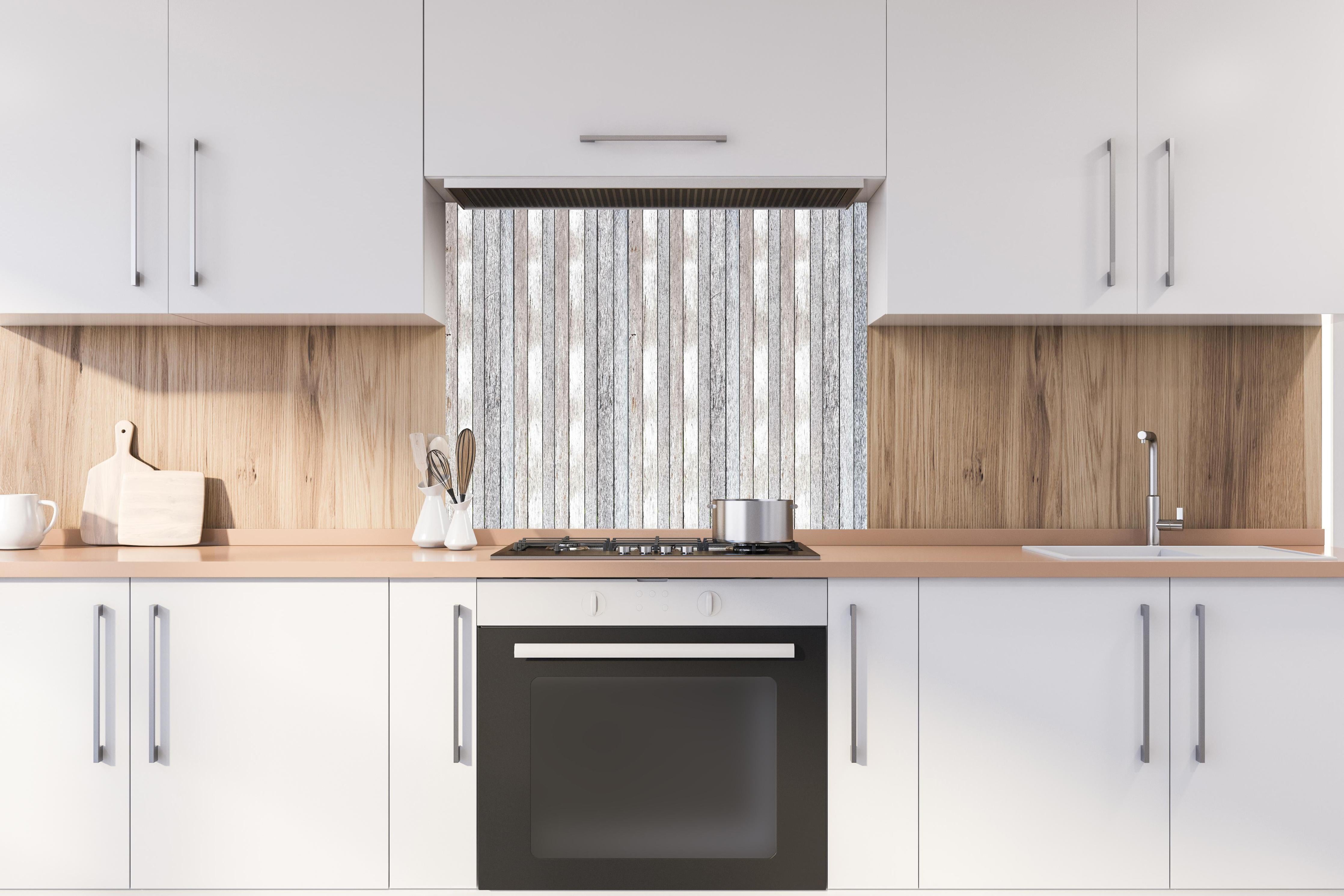 Spritzschutz - Pastellfarbene Vintage Holzwand hinter einem Cerankochfeld zwischen Holz-Kochutensilien
