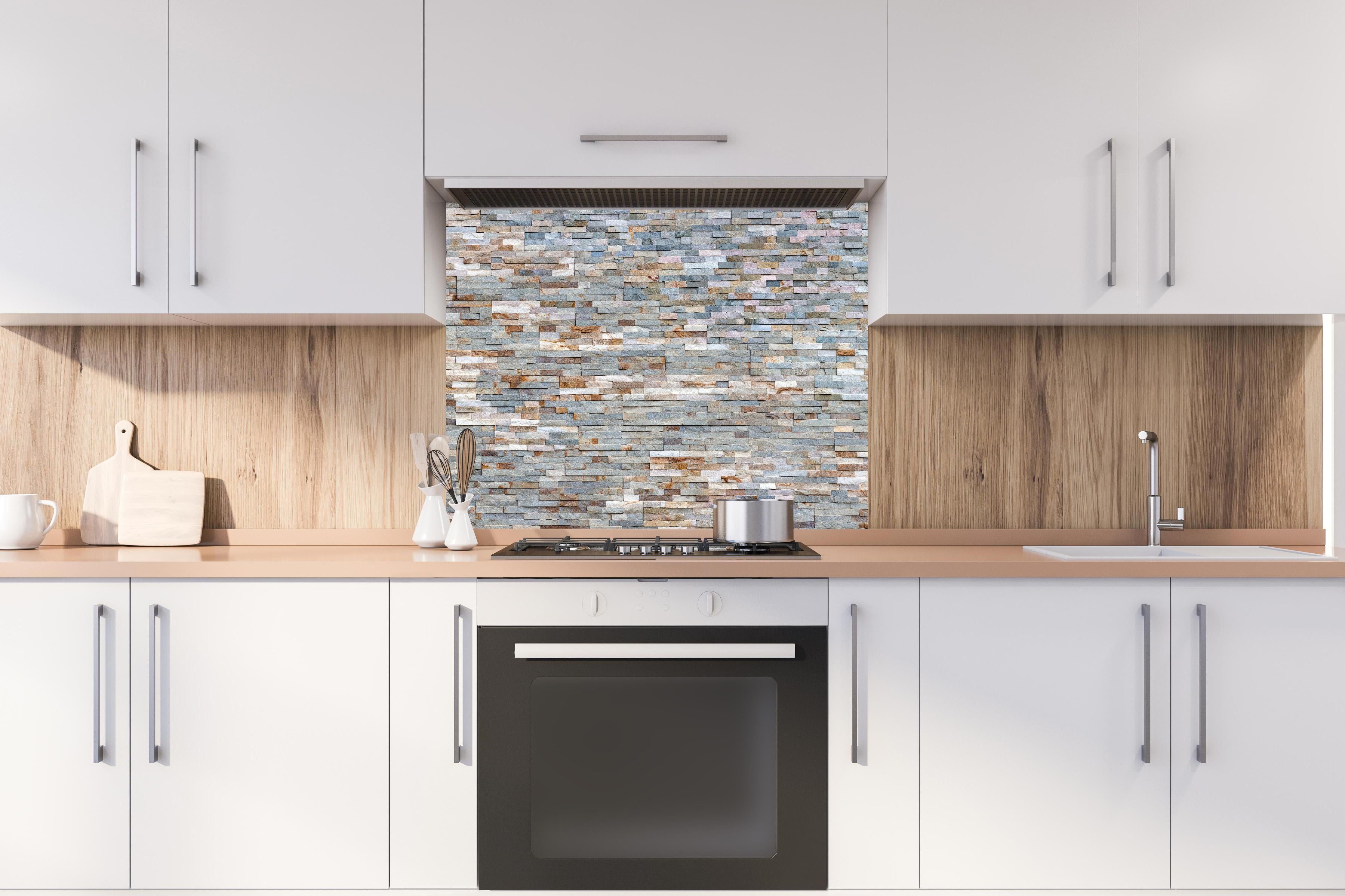 Spritzschutz - Pastellfarbige Schieferstein Textur hinter einem Cerankochfeld zwischen Holz-Kochutensilien
