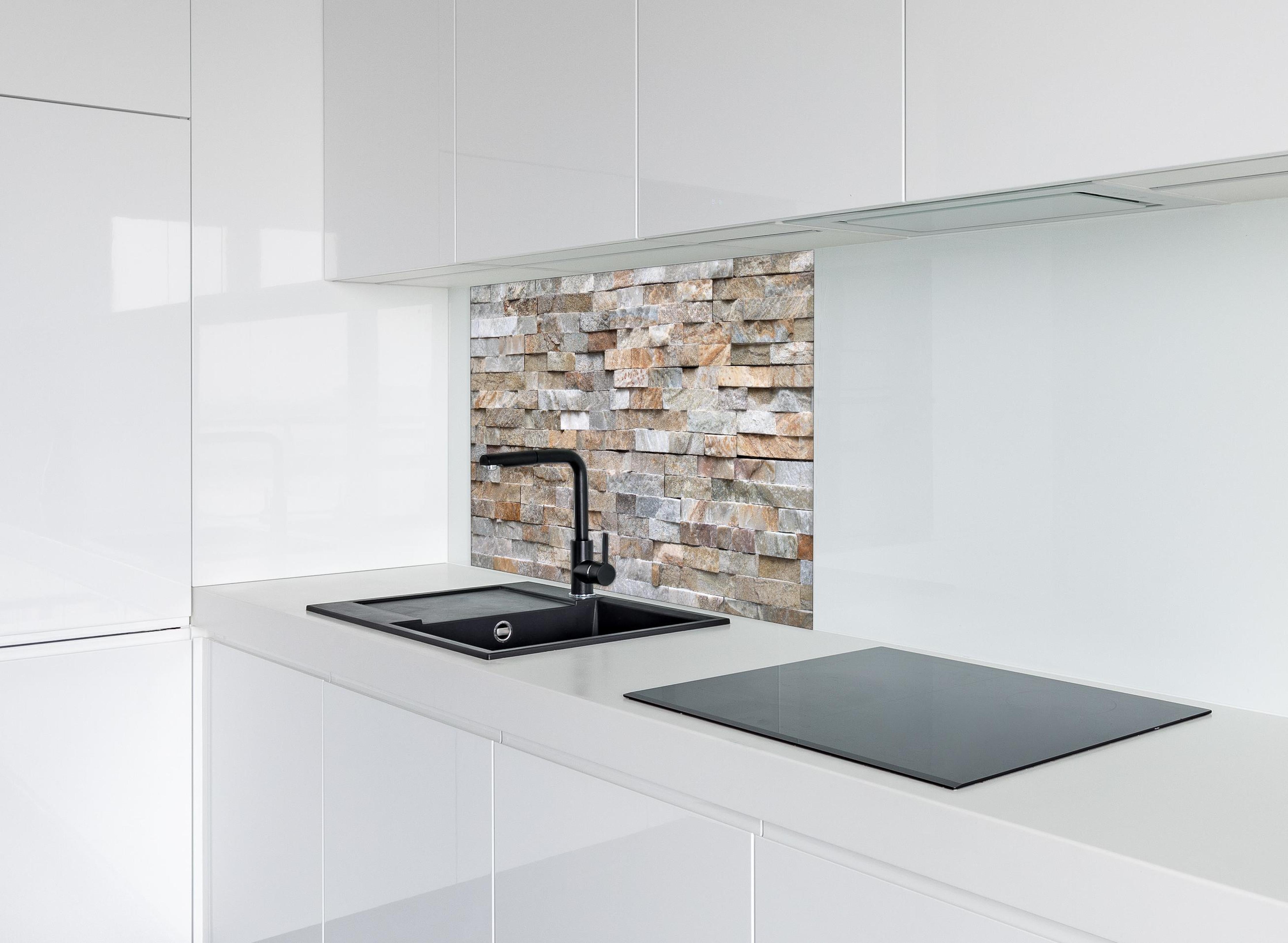 Spritzschutz - Pastellfarbige Steinmauer hinter einem Cerankochfeld zwischen Holz-Kochutensilien
