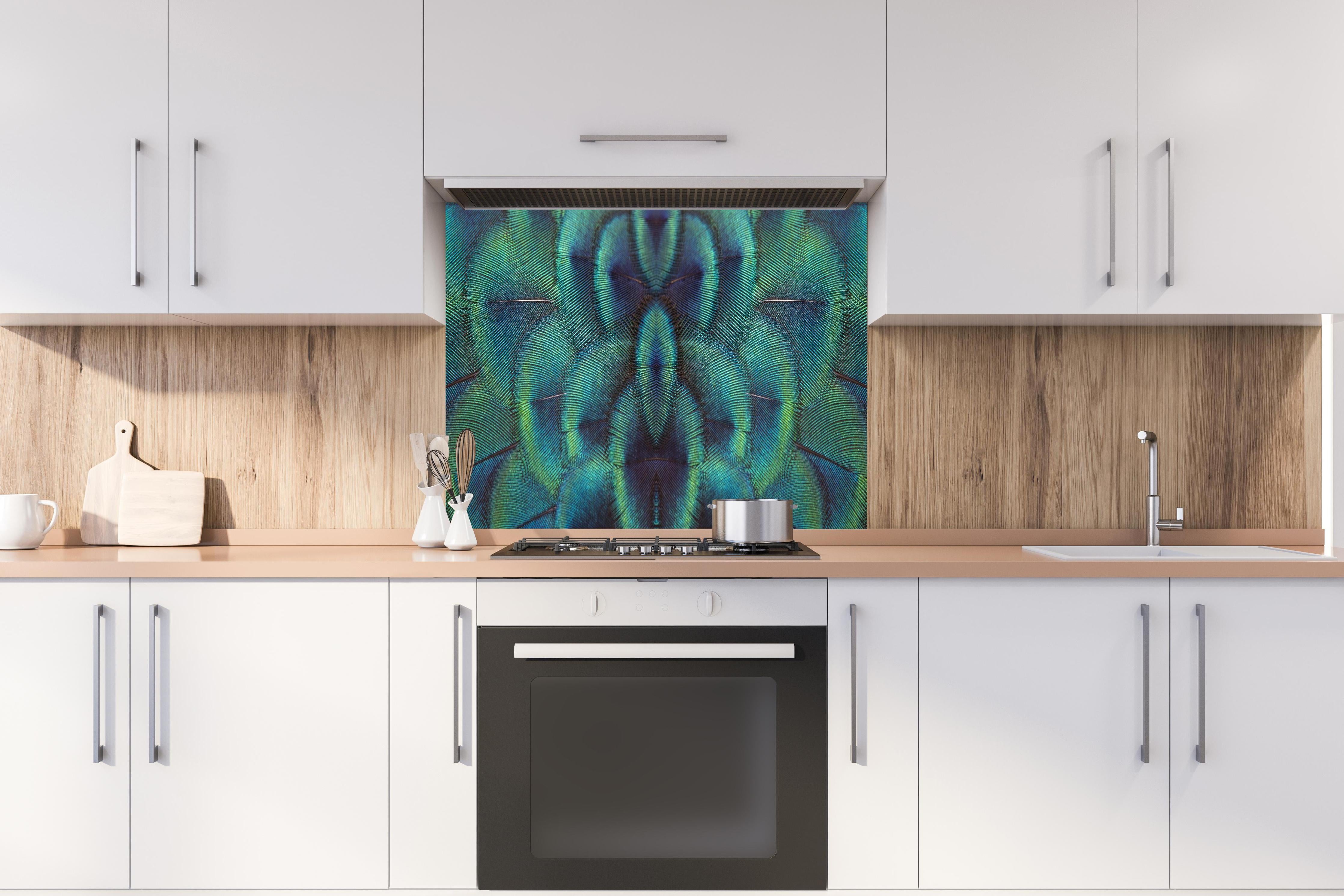 Spritzschutz - Pfauenfedern - Nahaufnahme hinter einem Cerankochfeld zwischen Holz-Kochutensilien
