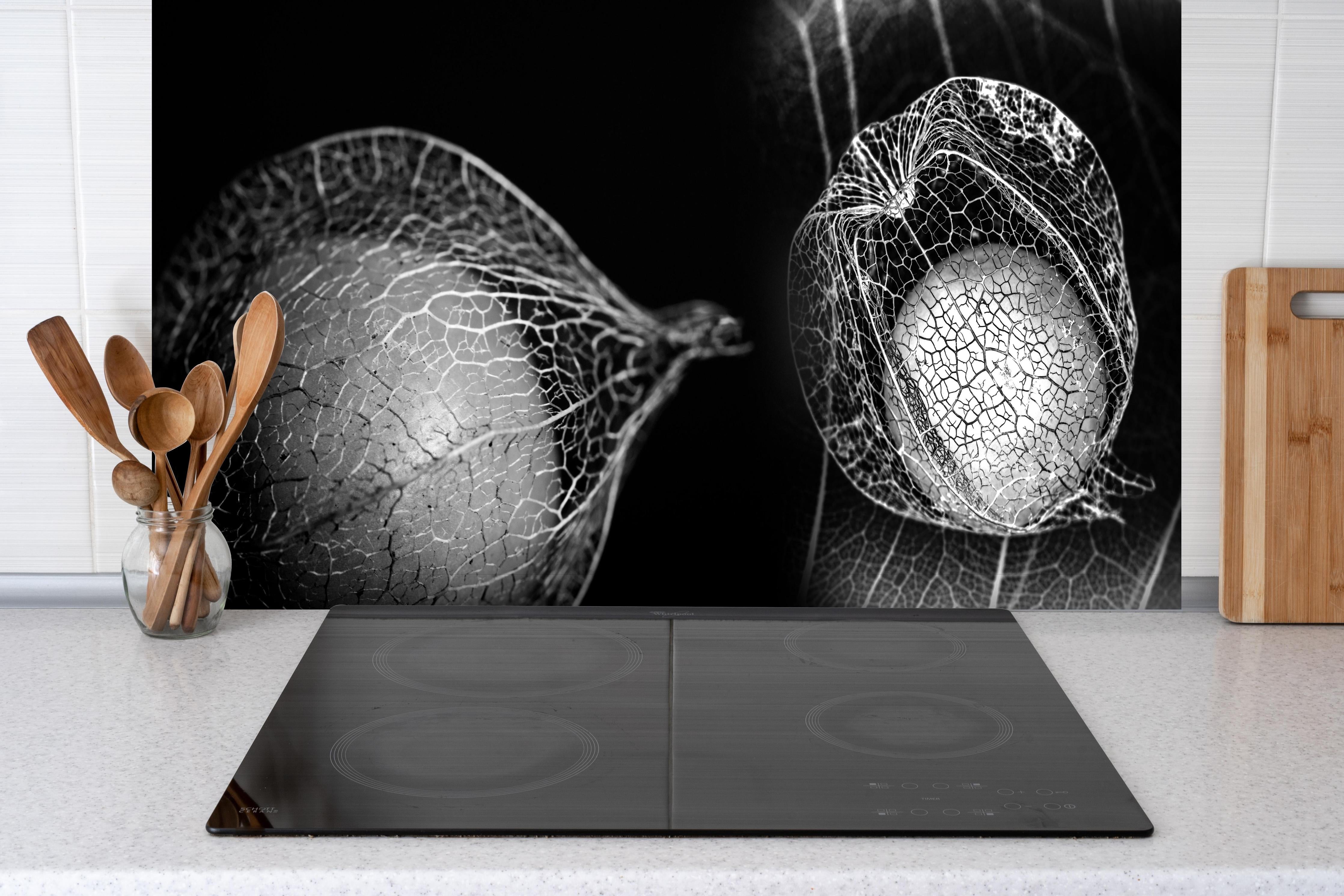 Spritzschutz - Pflanzen Makro-Netzstruktur in Grautönen hinter einem Cerankochfeld zwischen Holz-Kochutensilien
