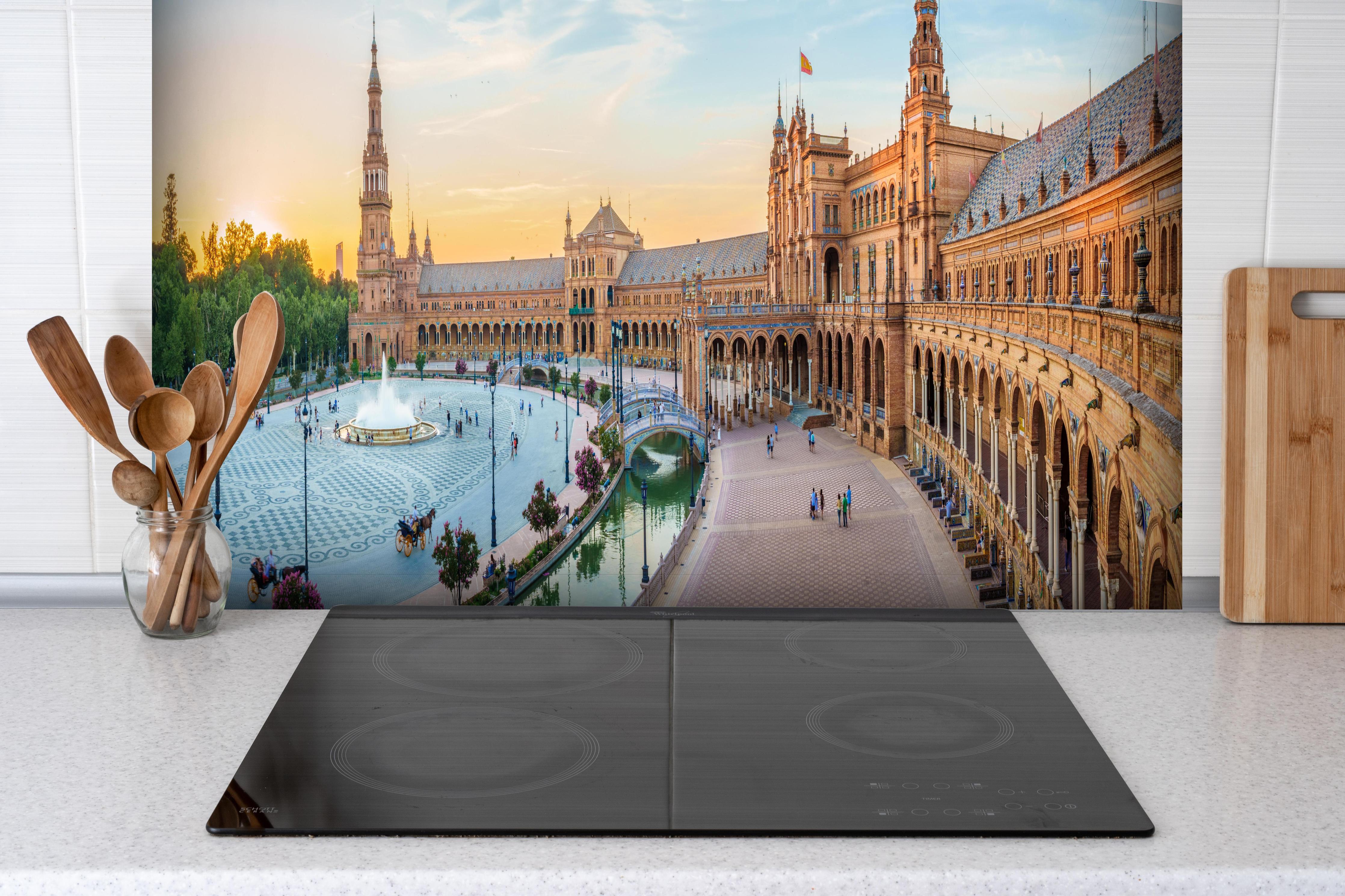 Spritzschutz - Plaza Espana Panorama in Abenddämmerung hinter einem Cerankochfeld zwischen Holz-Kochutensilien
