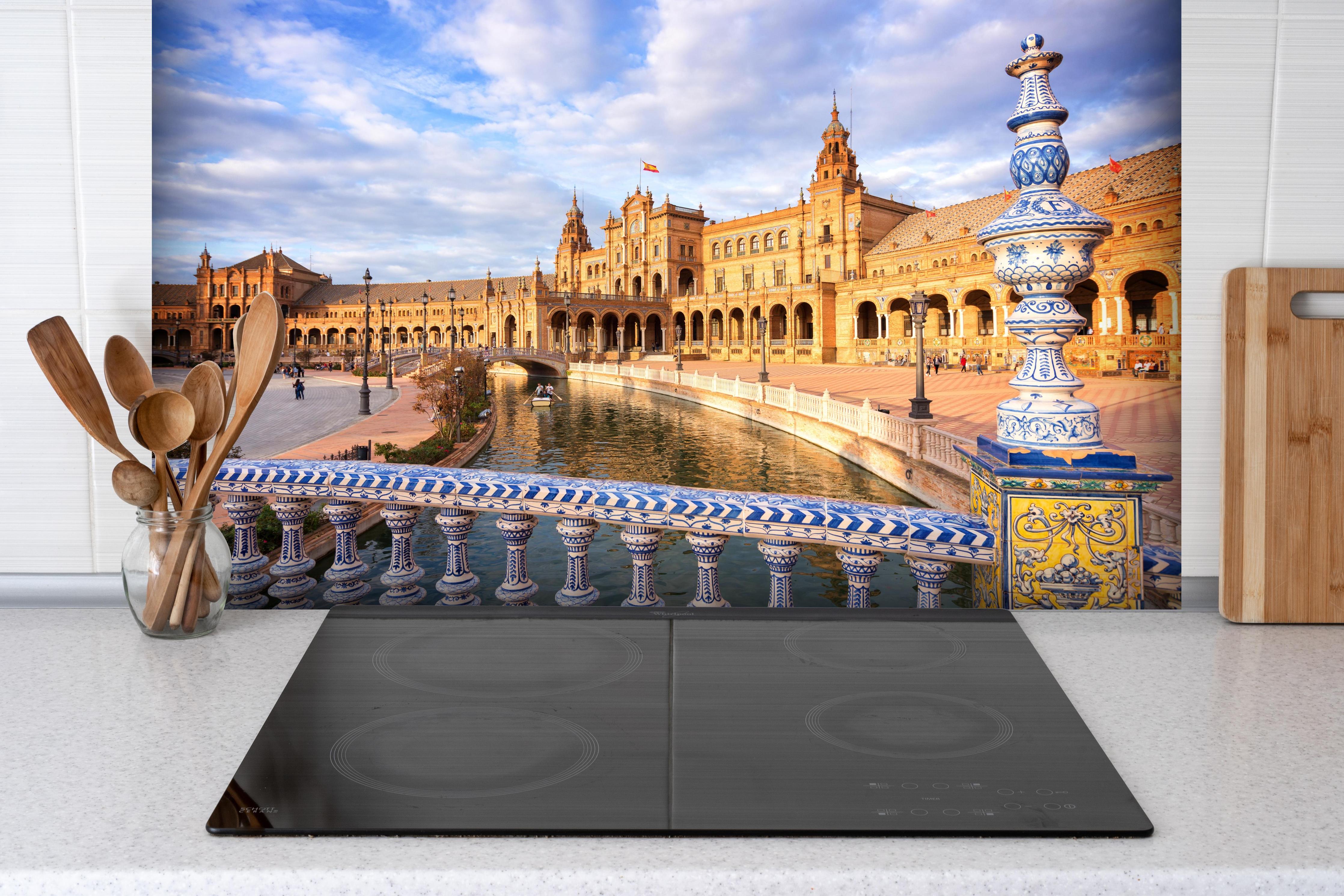 Spritzschutz - Plaza de Espana in Sevilla hinter einem Cerankochfeld zwischen Holz-Kochutensilien
