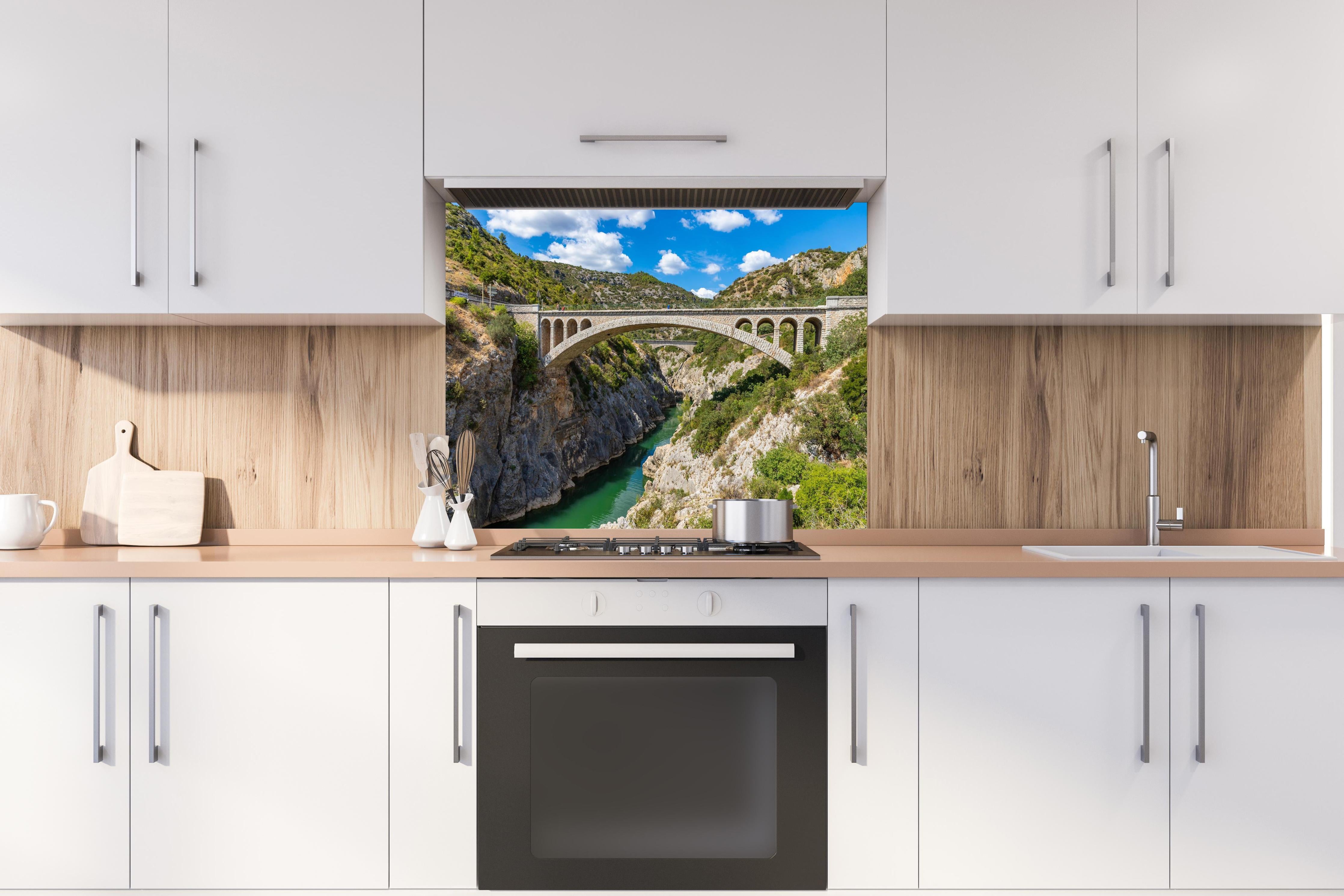 Spritzschutz - Pont du Diable - Frankreich  hinter einem Cerankochfeld zwischen Holz-Kochutensilien
