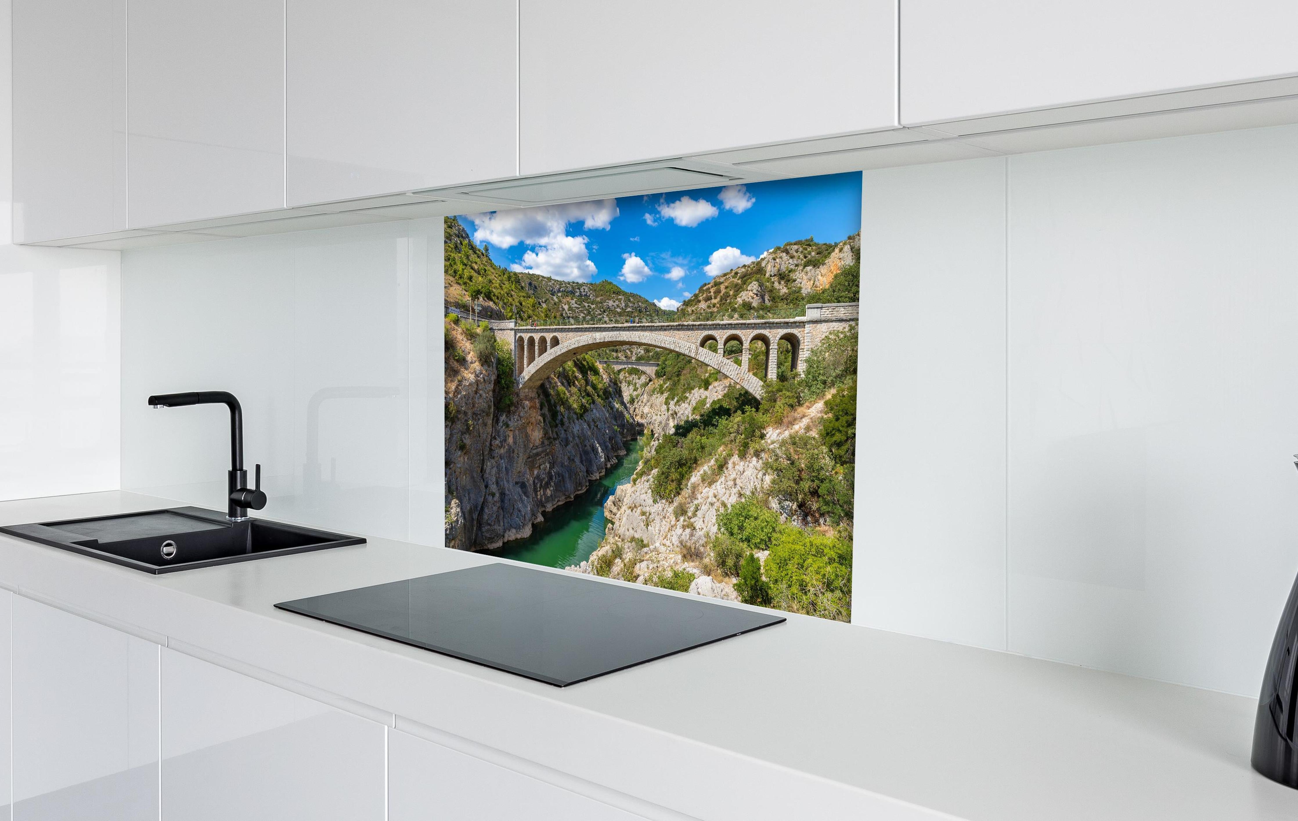 Spritzschutz - Pont du Diable - Frankreich  hinter einem Cerankochfeld zwischen Holz-Kochutensilien
